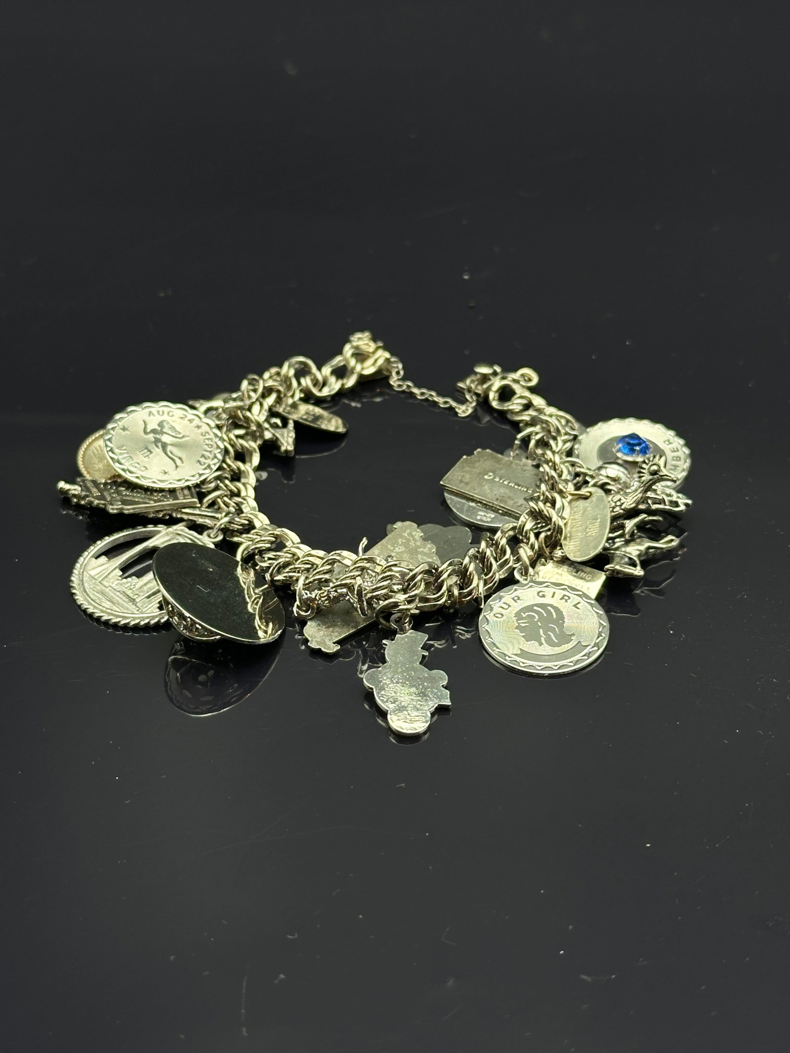Vintage ELCO Sterling Silver Charm Bracelet with Zodiac & Travel Charms: Vintage sterling silver charm bracelet by ELCO, stamped ELCO Sterling on the clasp. Bracelet is adorned with multiple charms including “Our Girl” medallion, Virgo zodiac disc (August–Septemb