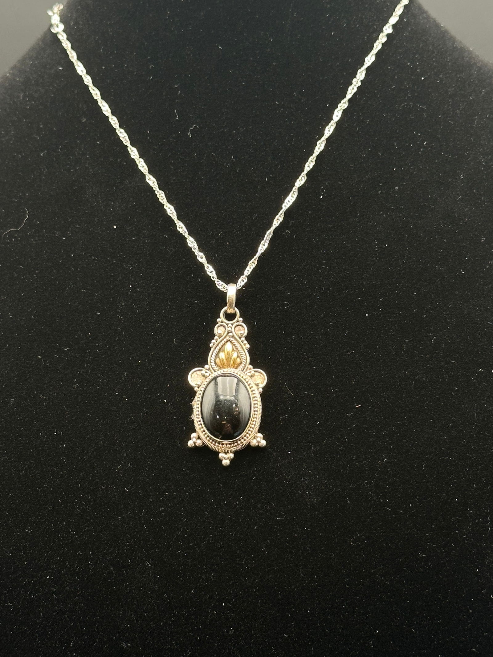 Vintage Sterling Silver .925 Pendant Necklace with Black Onyx Cabochon: Elegant vintage pendant necklace crafted in sterling silver .925, featuring an oval black onyx cabochon stone at the center. The pendant is beautifully detailed with intricate beaded silverwork and go