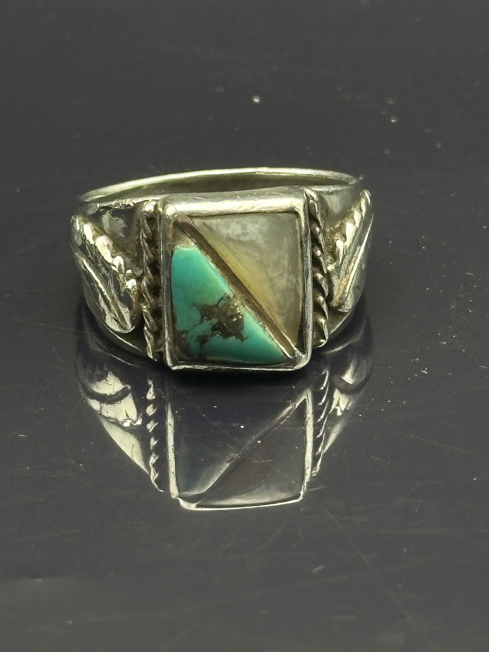 Vintage Navajo Sterling Silver Turquoise & Mother of Pearl Men’s Ring: A vintage Navajo sterling silver men’s ring featuring a geometric inlay of turquoise and mother of pearl (or shell), divided diagonally with a silver channel. The shank is decorated with traditional