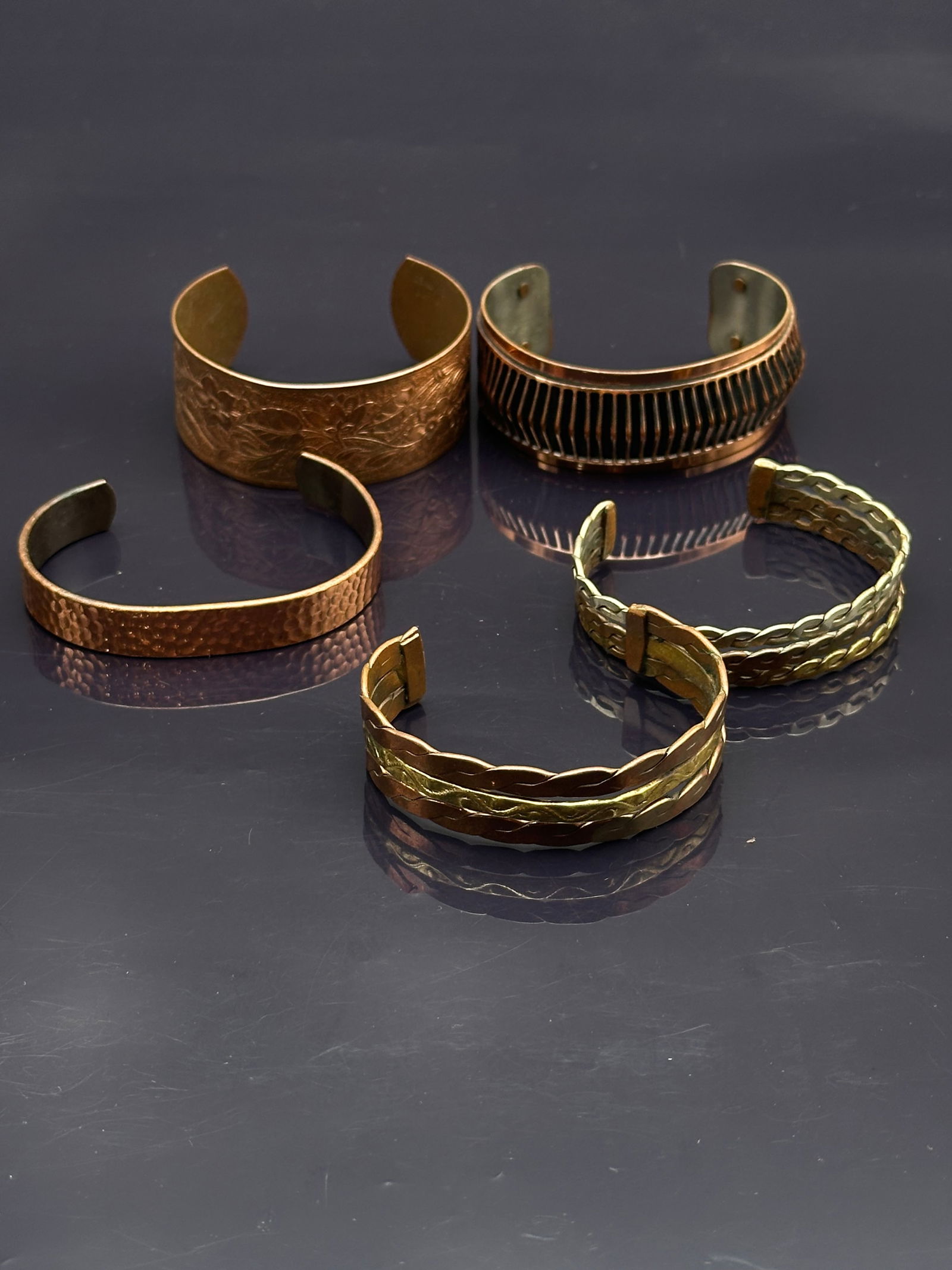 Lot of 5 Vintage Copper Cuff Bracelets – Hammered, Etched, and Braided Styles: Set of five vintage copper cuff bracelets, each with distinctive artisan character:•Hammered copper cuff with a hand-wrought texture•Floral-etched cuff with engraved botanical designs•R