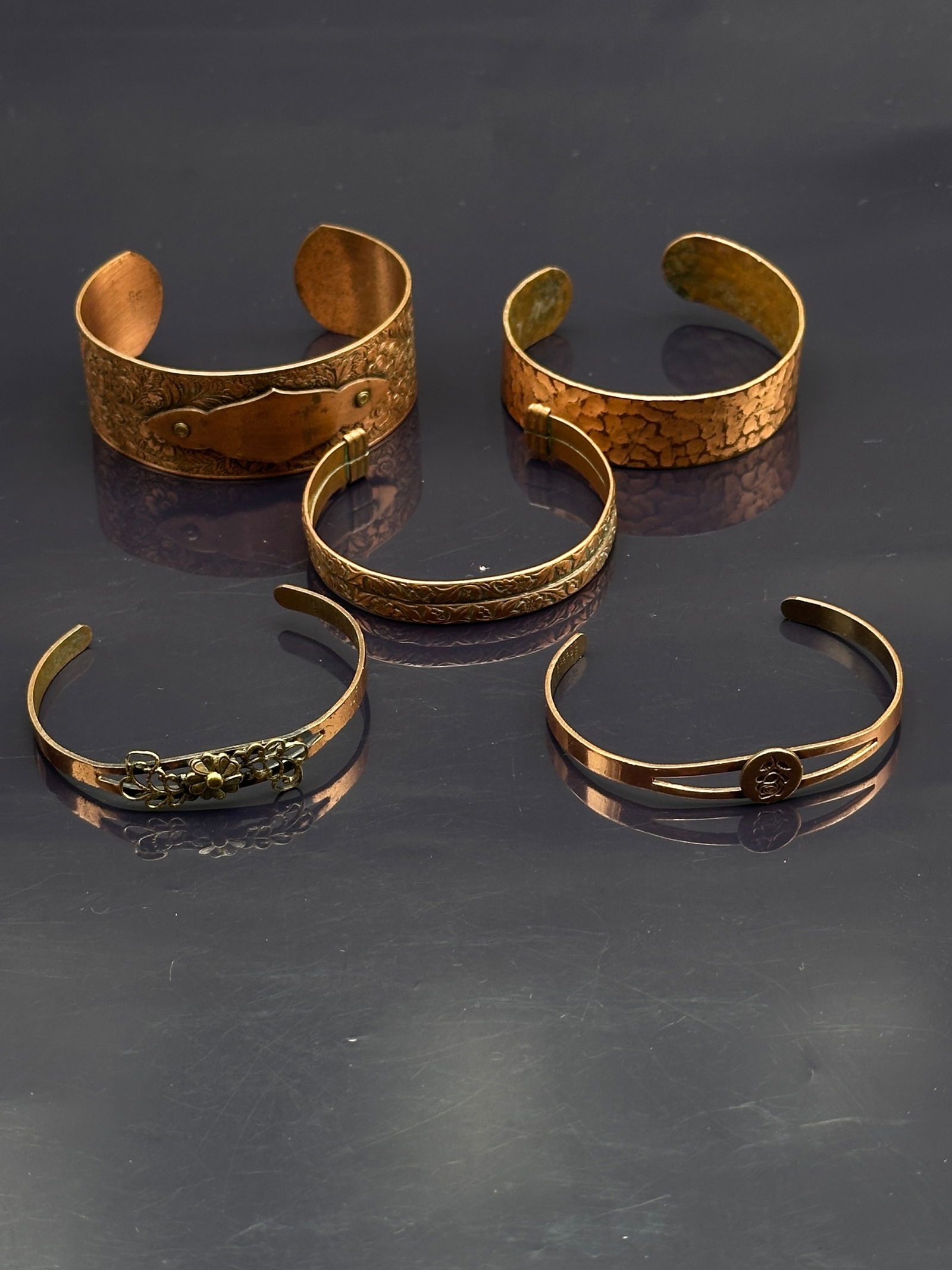 Lot of 5 Vintage Copper Cuff Bracelets – Etched, Hammered & Decorative Designs: Collection of five vintage copper cuff bracelets, each with unique craftsmanship and character:•Engraved wide cuff with raised nameplate accent•Hammered-texture cuff with a rustic, organic f