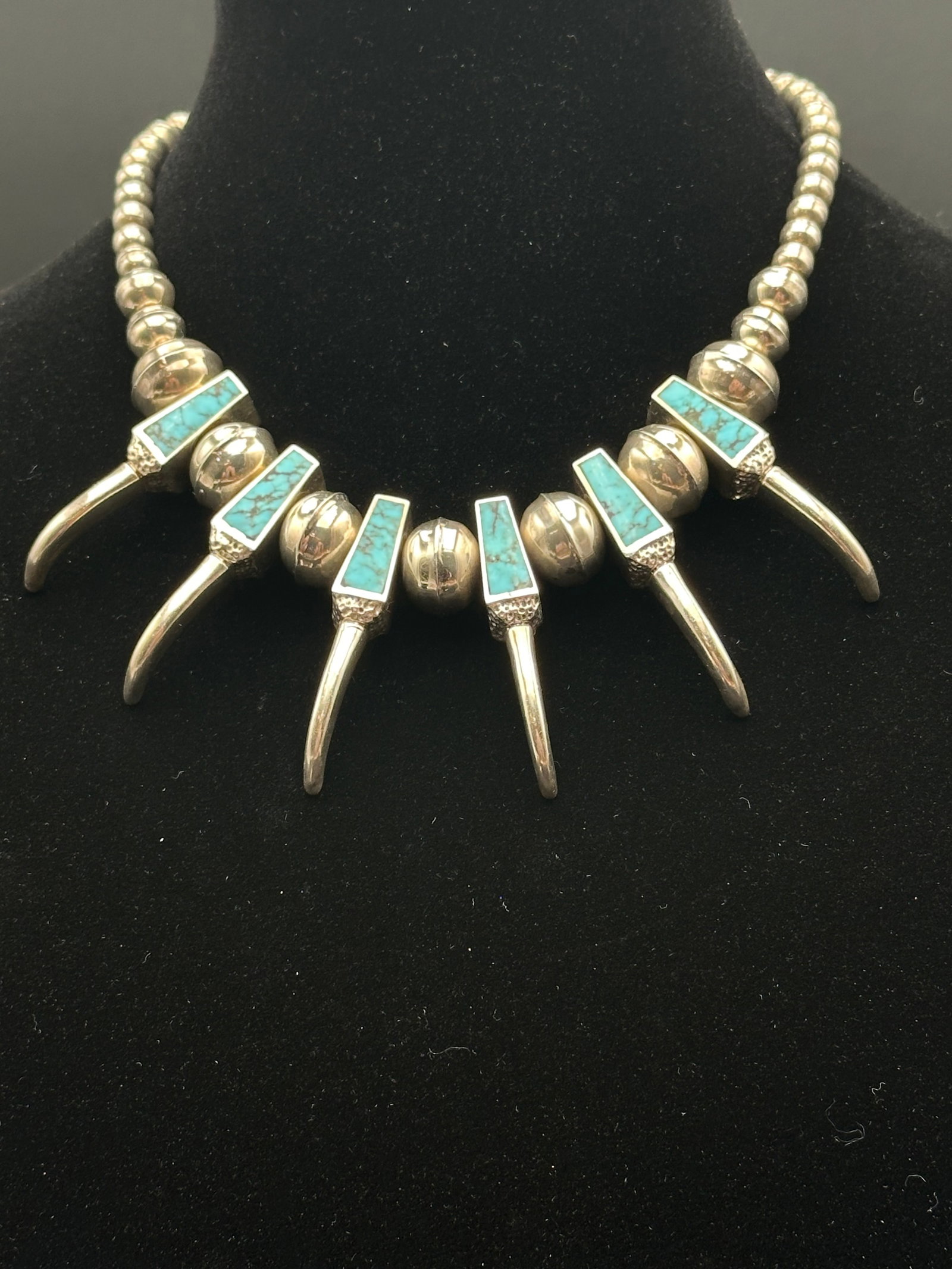 Vintage Navajo Sterling Silver & Turquoise Squash Blossom Necklace 32g: A beautifully crafted Navajo squash blossom necklace featuring sterling silver beads and squash blossoms, accented with turquoise inlay. The piece weighs 32 grams and showcases traditional Native Amer