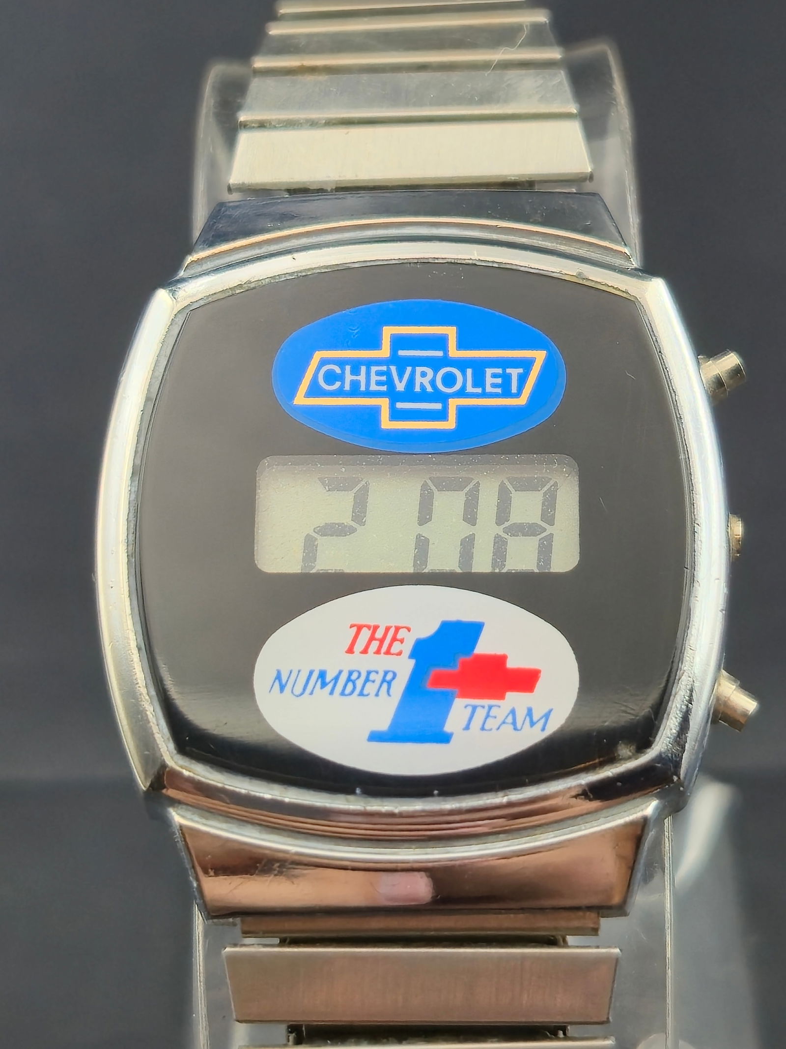 Vintage Chevrolet “The Number 1 Team” Digital LCD Watch w/ Stainless Bracelet – Runs: Vintage Chevrolet promotional digital wristwatch, featuring the Chevrolet bowtie logo and “The Number 1 Team” logo on the dial. Likely produced as a dealer or employee incentive in the late 19