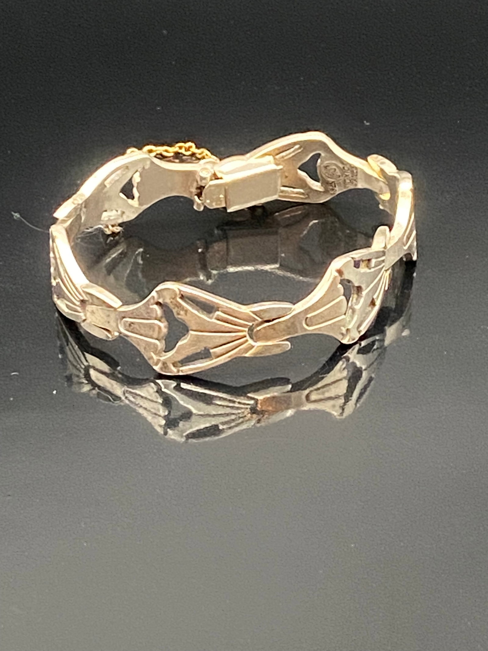 Vintage Sterling Silver Hinged Bracelet with Floral Openwork & Safety Chain: A vintage sterling silver hinged bracelet featuring elegant openwork floral motifs across the band. The bracelet is fitted with a secure clasp and an attached safety chain for added security. Measures