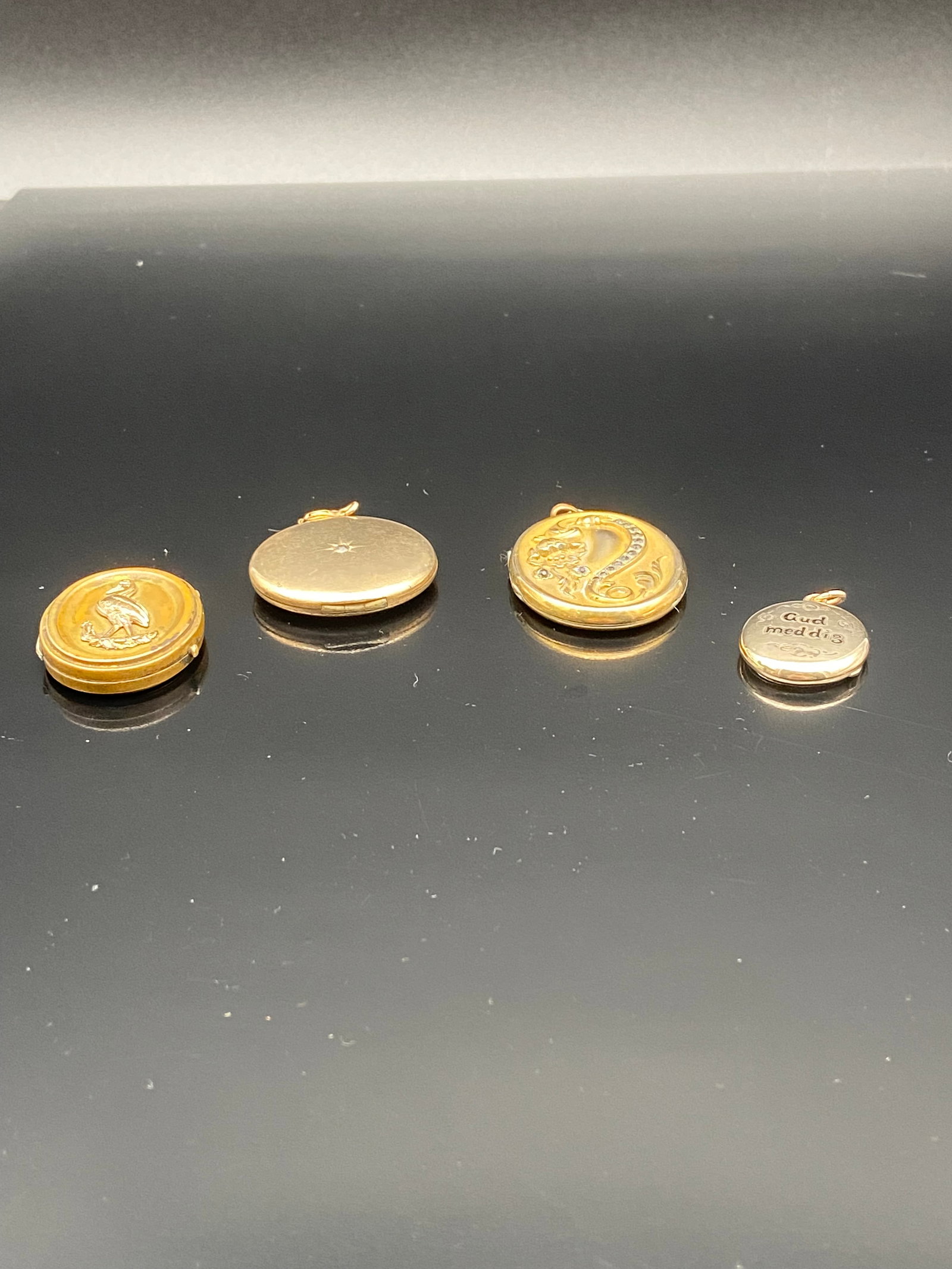 Set of 4 Vintage Gold-Tone Lockets with Portrait Inserts: A charming collection of four vintage lockets, each uniquely designed and retaining its nostalgic character. The lockets range in size and detail, with delicate engravings and classic oval shapes. Som