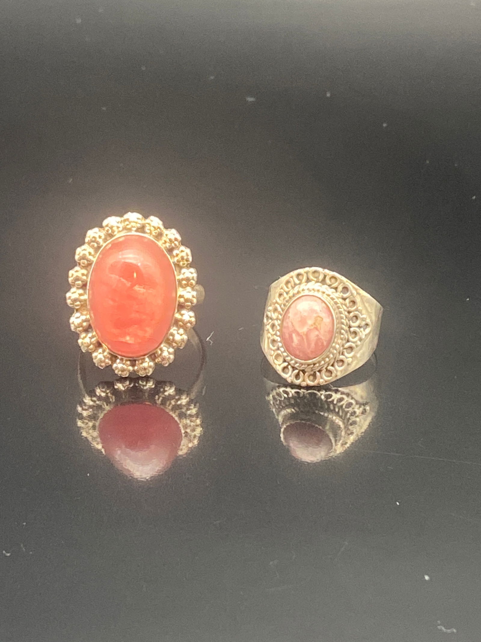 Pair of Vintage Cameo Rings with Coral-Pink Resin Intaglios: A charming pair of vintage cameo-style rings, each featuring a coral-pink resin intaglio portrait:•Left Ring: A bold oval cameo framed by an ornate beadwork-style border, creating a striking and