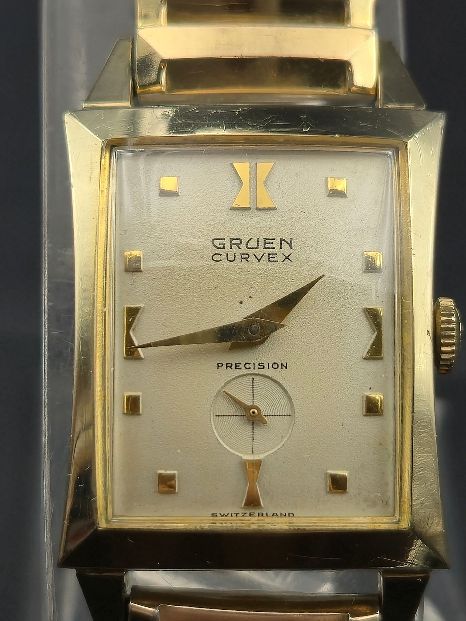 1950s Gruen Curvex Precision 370 10K GF 30mm Rectangular Watch w/ Box: Up for auction is a vintage 1950s Gruen Curvex Precision wristwatch, one of Gruen’s most iconic designs, built around their patented curved movement to better fit the wrist.The rectangular case is m