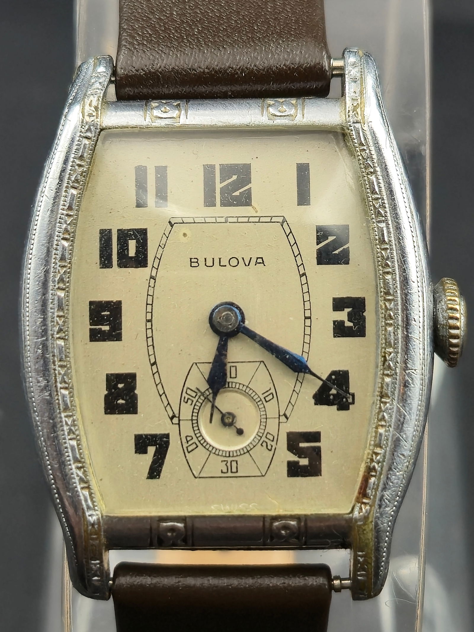 1934 Bulova 27mm Tonneau Art Deco Wristwatch, 15J Cal. 10AL, Engraved Case, Sub-Seconds, Running: Vintage 1934 Bulova men’s wristwatch in a classic Art Deco tonneau case with detailed side engraving and period dial. The watch measures 27mm wide and houses a Bulova 15-jewel manual wind movement,