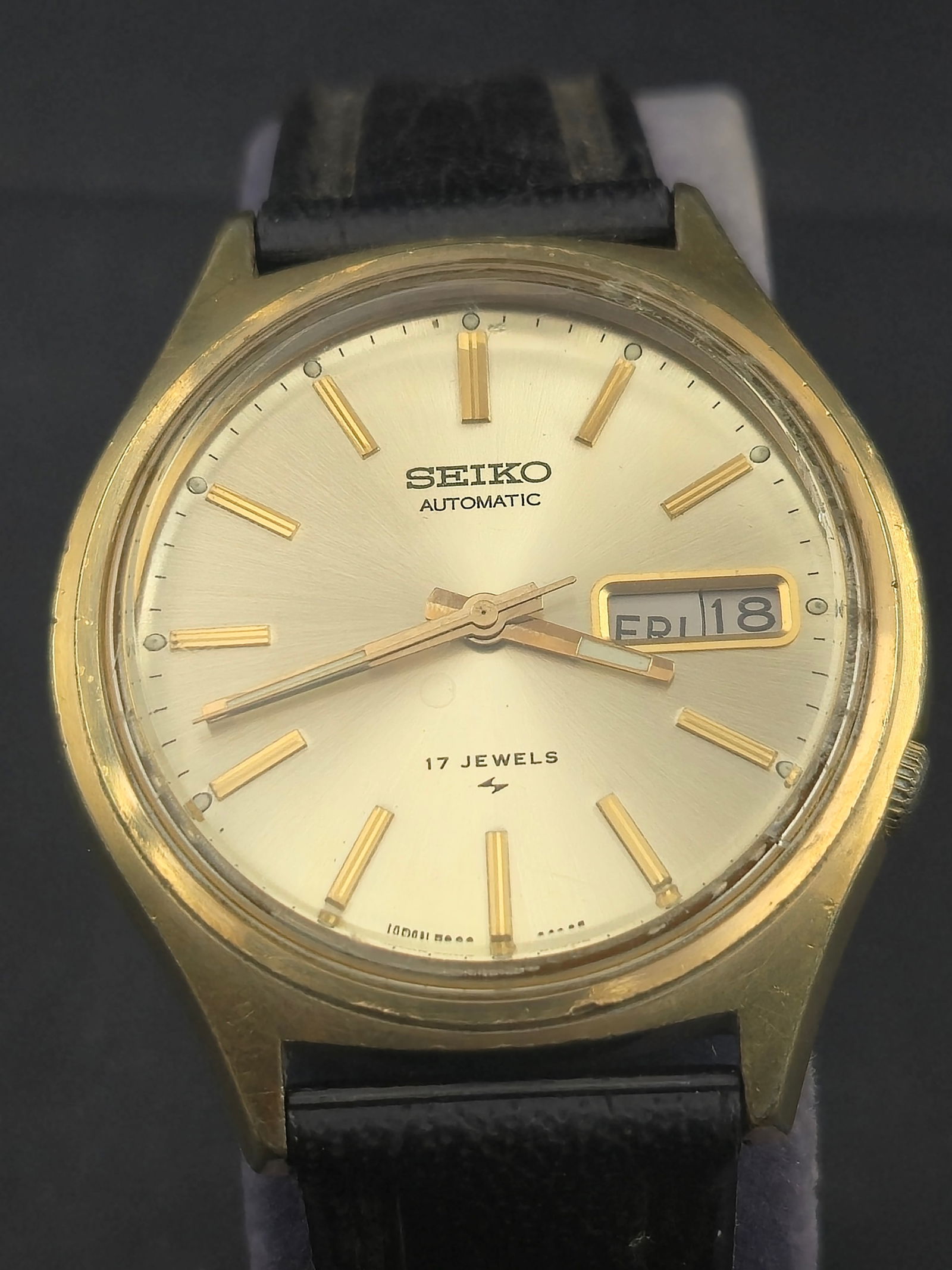 1975 Seiko 7009-8029P Automatic 17J Gold-Tone 37mm Vintage Day-Date Wristwatch Running: Vintage Seiko 7009-8029P automatic wristwatch from May 1975, featuring a 37mm gold-tone case with stainless steel back and powered by the Seiko 7009 automatic movement with 17 jewels. The silver sunbu