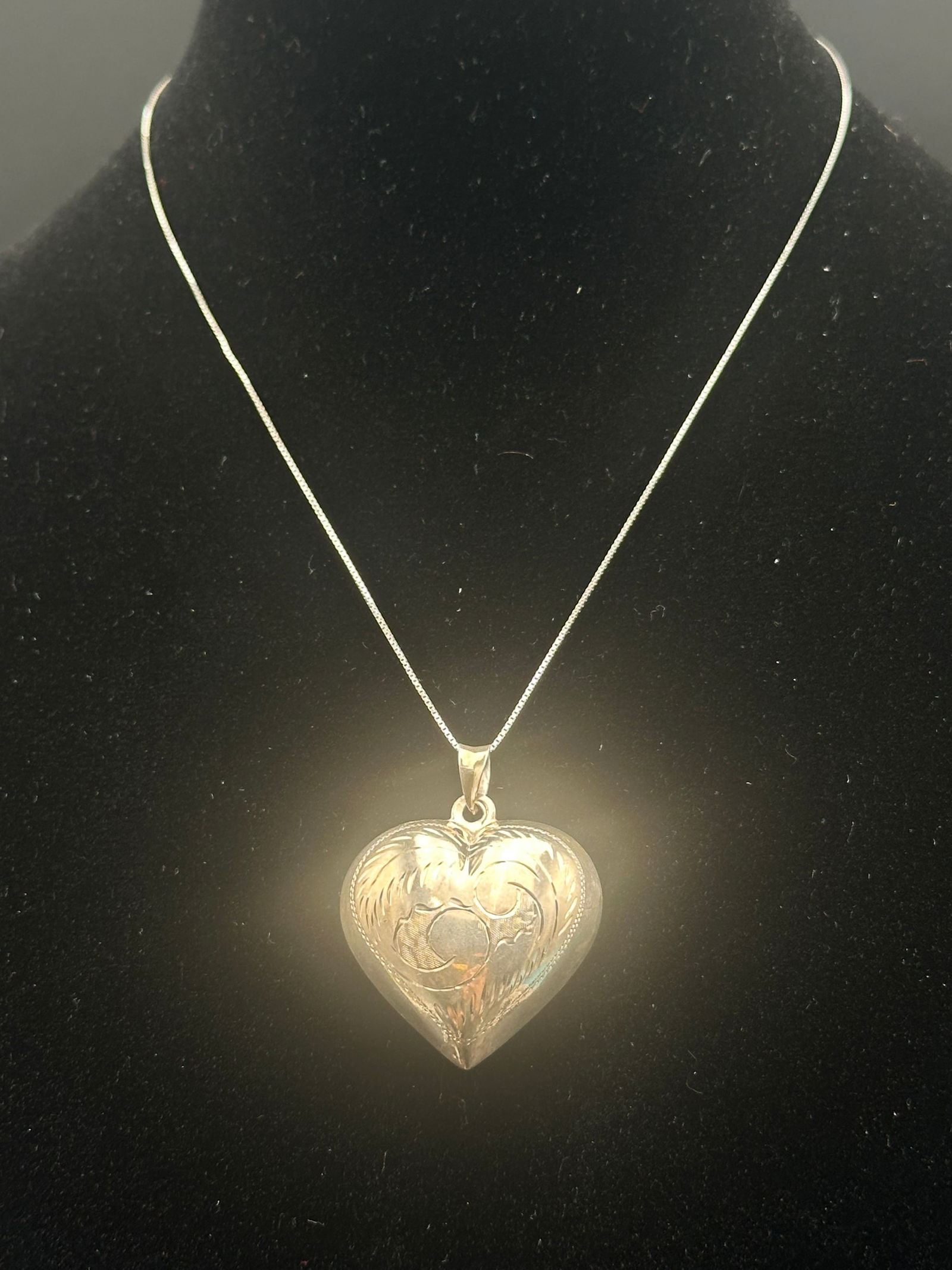 Vintage Sterling Silver Heart Pendant Necklace on Italian Chain: A vintage sterling silver heart pendant with ornate scrollwork engraving on the front, suspended from a sterling silver box chain marked “925 Italy.” The heart pendant has a classic and timele