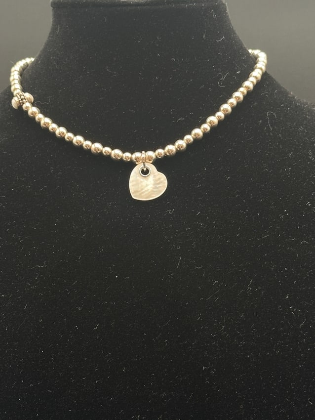 Sterling Silver Beaded Choker with Hammered Heart Pendant: Elegant sterling silver choker featuring polished round beads and a central hammered heart charm. The design is accented with a decorative beaded spacer for added detail. Perfect for layering or weari