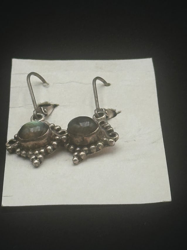 Vintage Sterling Silver Earrings with Labradorite Gemstones: A pair of vintage sterling silver dangle earrings, featuring oval cabochon-cut labradorite stones set in ornate silver beaded frames. The gemstones display natural flashes of green and blue iridescenc