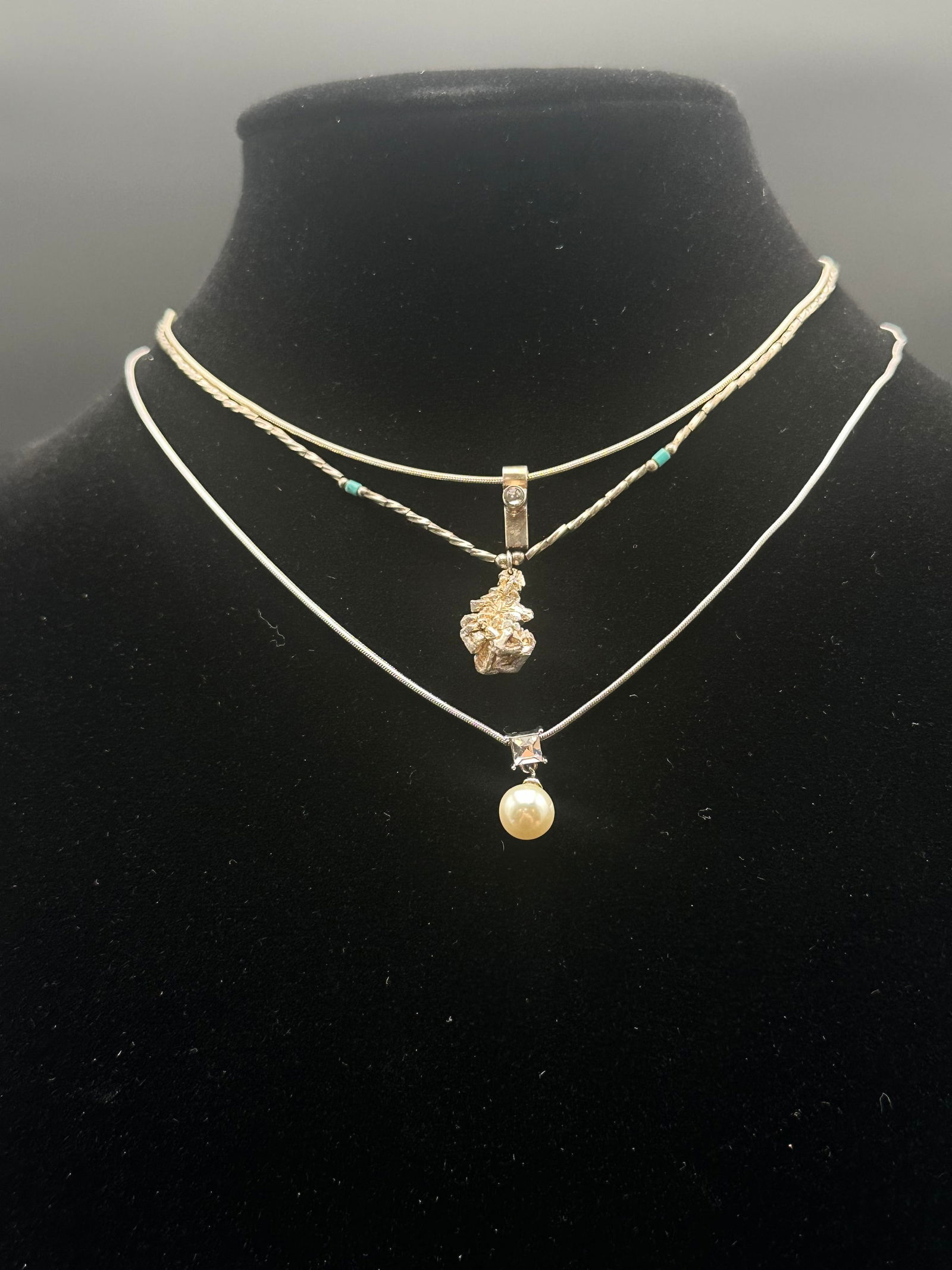 Lot of 3 Sterling Silver & Gold-Tone Necklaces – Nugget, Pearl, and Minimalist Bar Pendants: A chic trio of necklaces including a gold nugget-style pendant on a beaded silver strand with turquoise accents, a modern silver bar pendant with clear crystal, and an elegant pearl drop necklace set