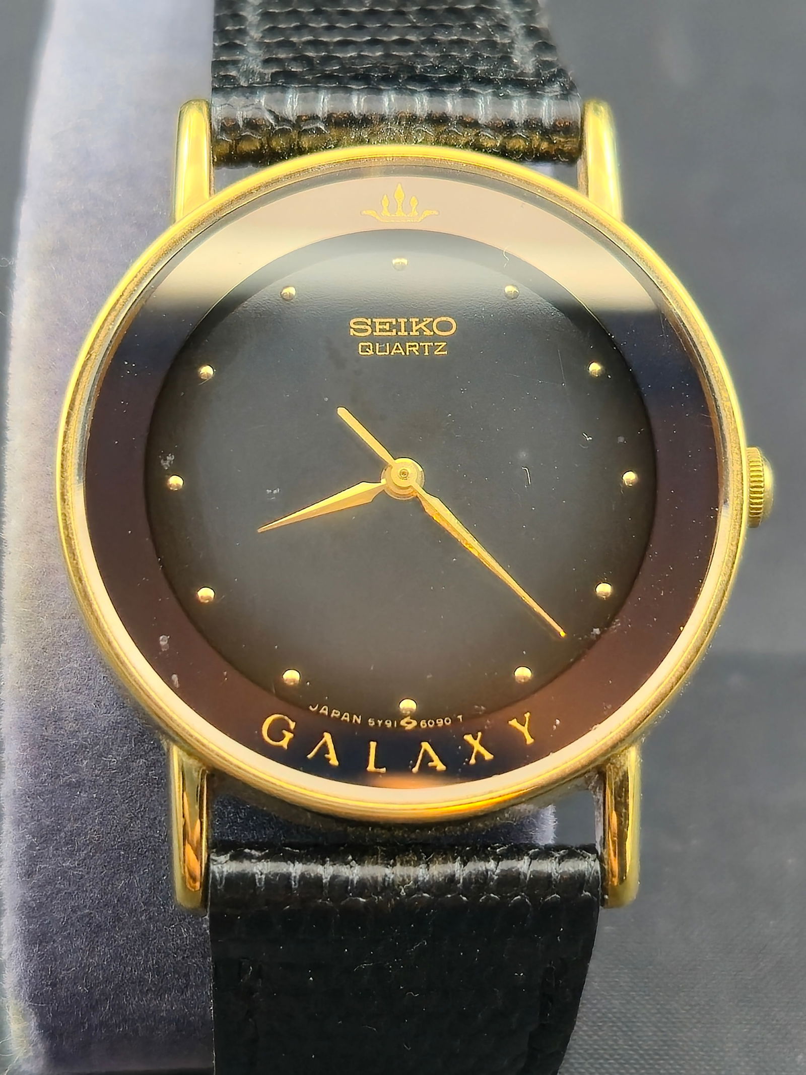 1988 Seiko Galaxy Quartz Ref. 5Y91-6060 Dress Watch – 30mm: This Seiko Galaxy dress watch from June 1988 features an elegant minimalist design. The glossy black dial is accented only with gilt dot hour markers and slim gold-tone dauphine hands. “Galaxy&rdquo