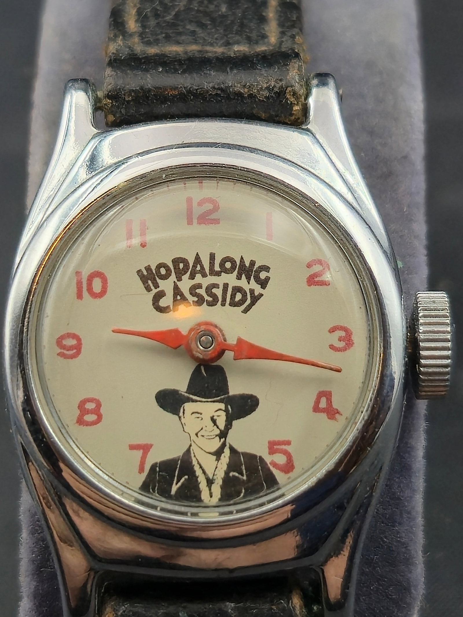 1950s U.S. Time Hopalong Cassidy Character Watch – All Original, Running, Western Strap – 23mm: This highly collectible Hopalong Cassidy wristwatch was produced by U.S. Time Co. in the early 1950s at the height of the Western hero’s popularity. The cream dial features a portrait of Hopalong Ca