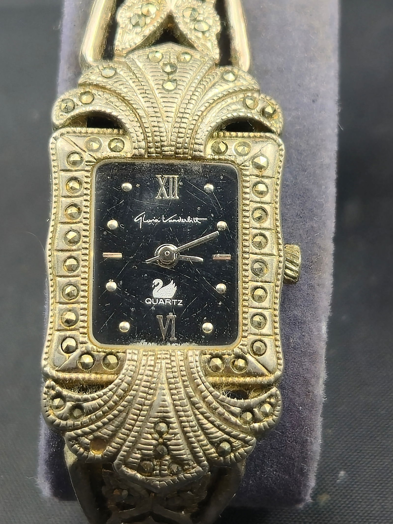 Vintage Gloria Vanderbilt Ornate Quartz Ladies Watch Marcasite Style Case: vintage Gloria Vanderbilt ladies’ quartz wristwatch with an ornate Art Deco revival style case and bracelet. The bezel and integrated band feature marcasite-style decorative accents with filigree an
