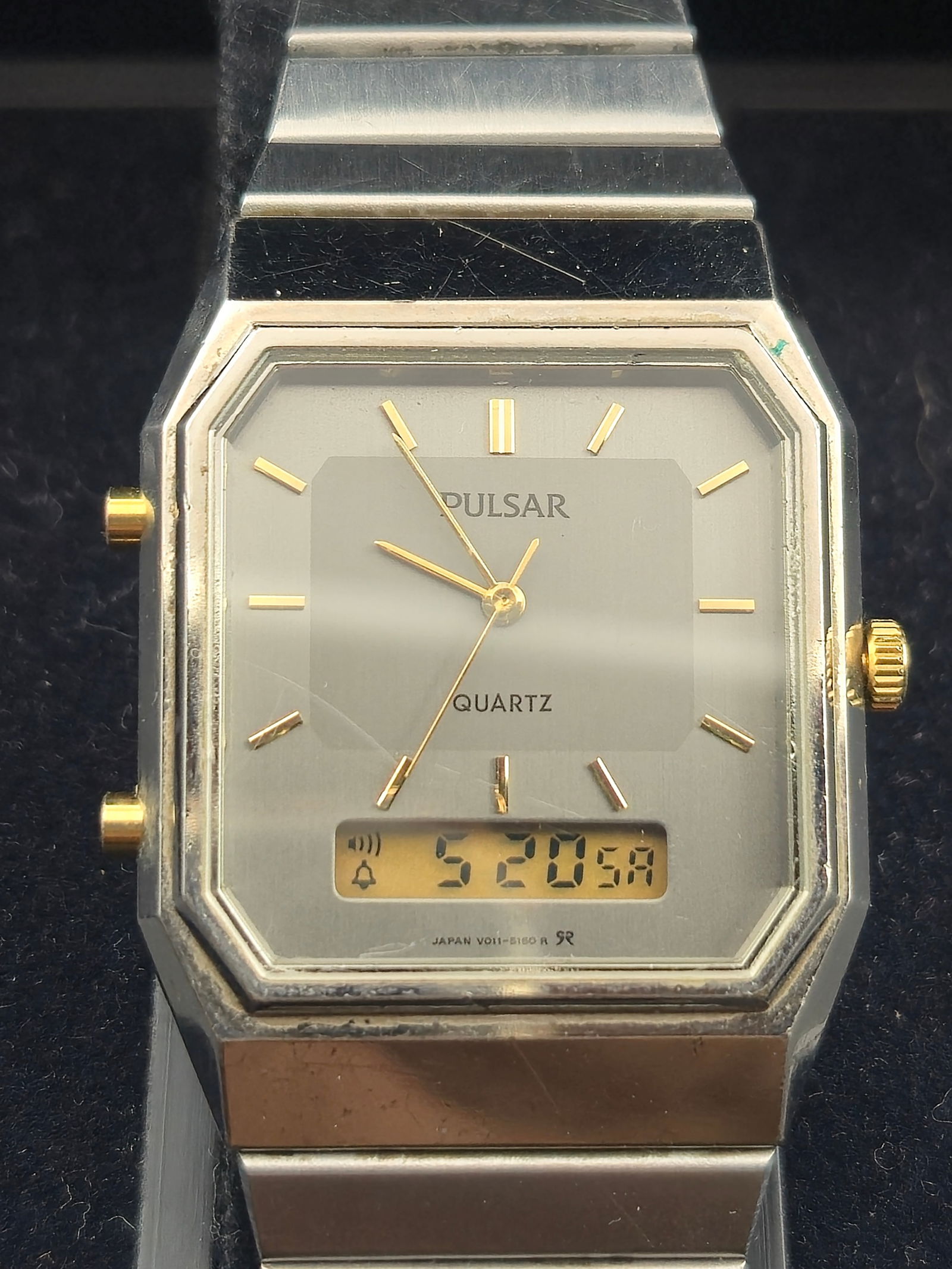 Vintage Pulsar Quartz V011-5100 Ana-Digi Men’s Watch Silver-Tone w/ Box – Japan – Running: This is a vintage Pulsar Quartz ana-digi wristwatch, reference V011-5100, featuring both analog hands and a digital display. The rectangular octagonal case measures approximately 31mm across and is fi