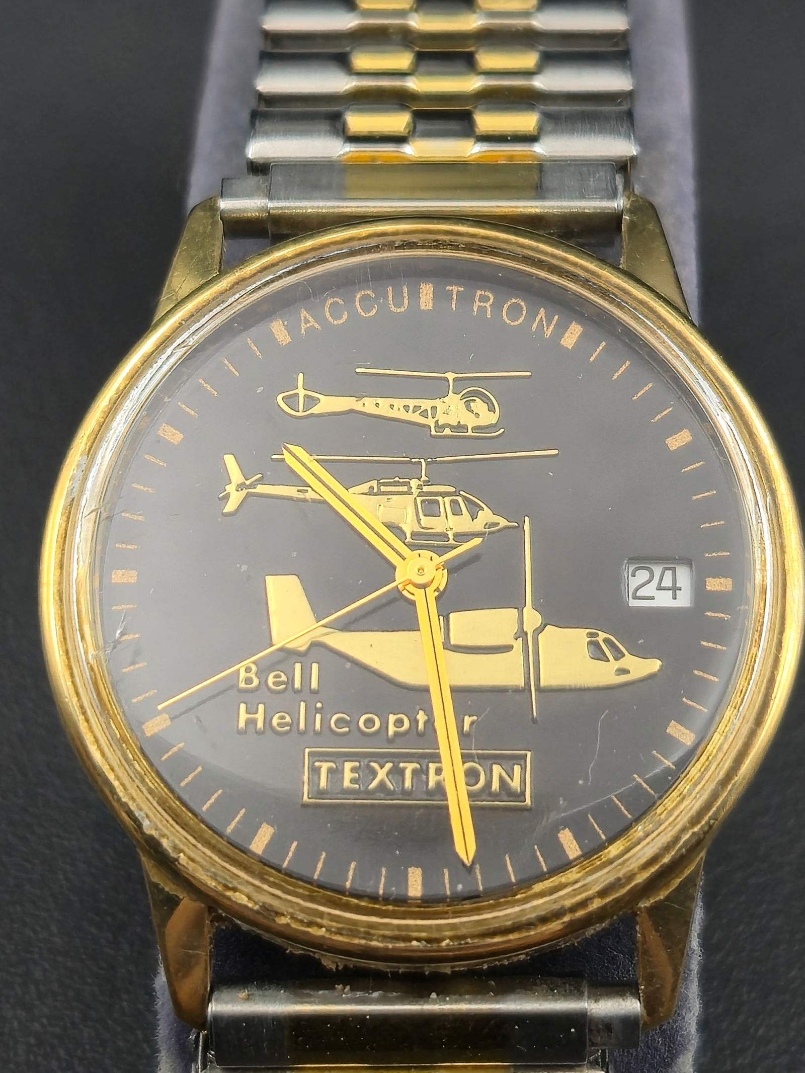 1989 Bulova Accutron Bell Helicopter Textron Service Watch 33mm Gold-Tone: A 1989 Bulova Accutron wristwatch presented for 25 years of service with Bell Helicopter Textron. The black dial is decorated with gold-tone silhouettes of Bell aircraft and branded “Bell Helicopter