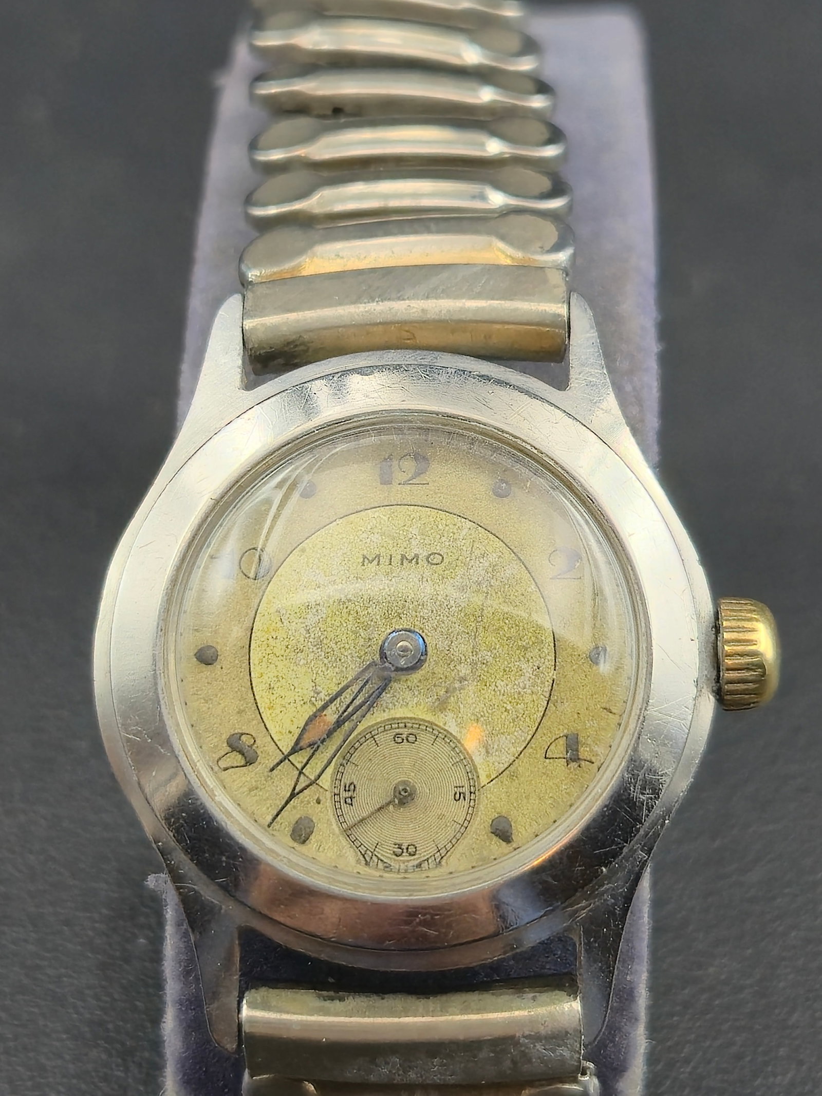 1940s MIMO Watch Co. 15J Swiss Manual Wind 29.6mm Stainless Steel Wristwatch: Vintage MIMO Watch Co. Swiss manual-wind wristwatch from the 1940s featuring a 15-jewel movement marked “MIMO Watch Co. Swiss Unadjusted.” The watch retains its original aged two-tone dial wit