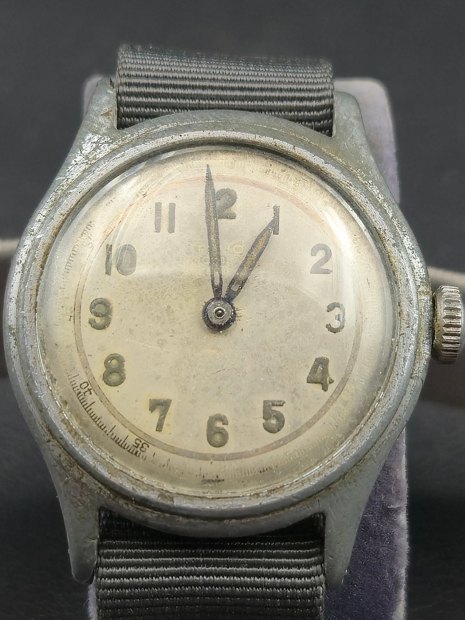 1950s Tevo “Military Field Watch” Swiss 17J Manual Wind 30.8mm (Running, New Crystal): Vintage Tevo Military Field Watch featuring a Swiss-made 17-jewel manual-wind movement housed in a rustless steel back case. The silvered dial displays luminous Arabic numerals, blued steel hands, and