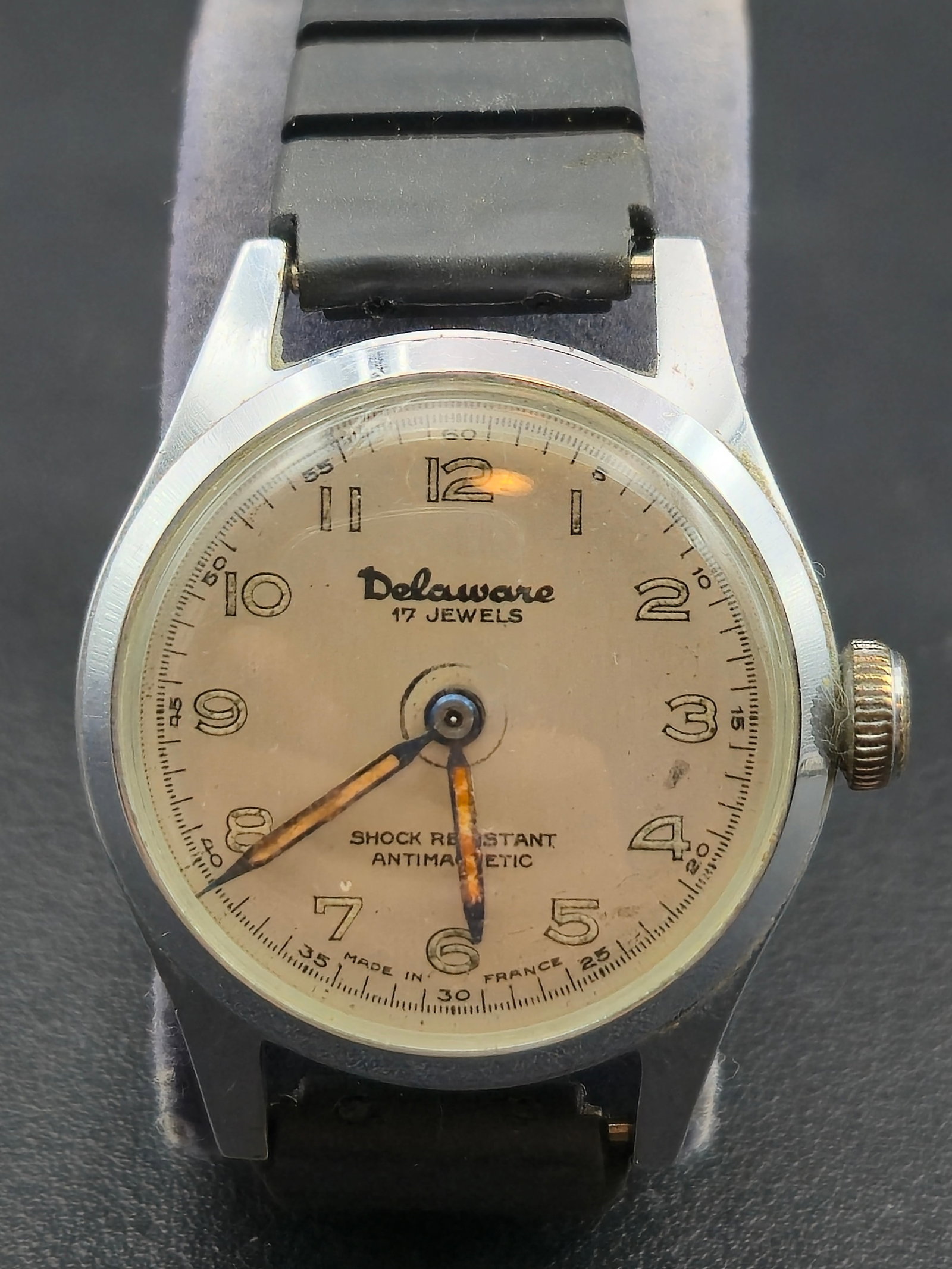 1950s Delaware “French Military Style” 17J Manual Wind 30mm Wristwatch: Vintage Delaware French Military Style wristwatch featuring a 17-jewel manual-wind movement made in France, signed Delaware Watch France. The cream dial displays luminous Arabic numerals, blued hands,