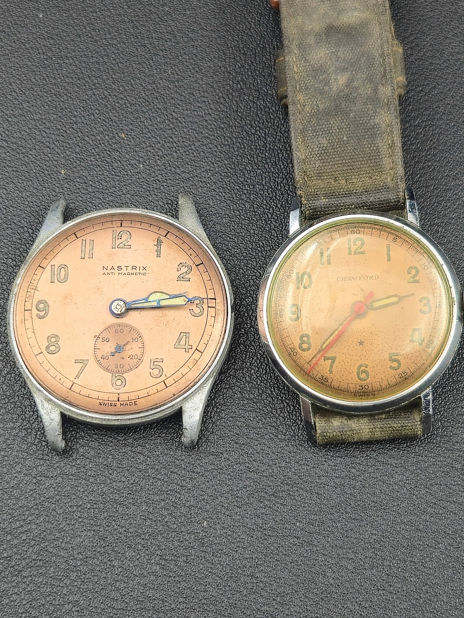 1940s–50s Pair of Swiss Military-Style Wristwatches Nastrix & Crawford 15J/17J –: Pair of vintage Swiss-made manual-wind wristwatches from the mid-20th century, both featuring classic military-inspired styling and aged copper dials.The first is a Nastrix Anti-Magnetic men’s watch