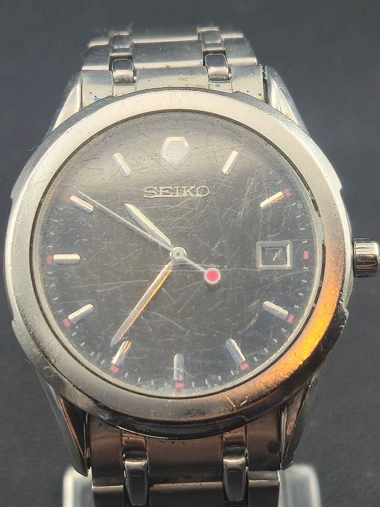 Seiko 7N42-9089 Stainless Steel Quartz Watch 37.5mm running: Classic Seiko 7N42-9089 men’s stainless steel wristwatch with minimalist silver-tone dial, applied baton indices, and red-accent seconds hand. The case measures 37.5mm across and features the origin