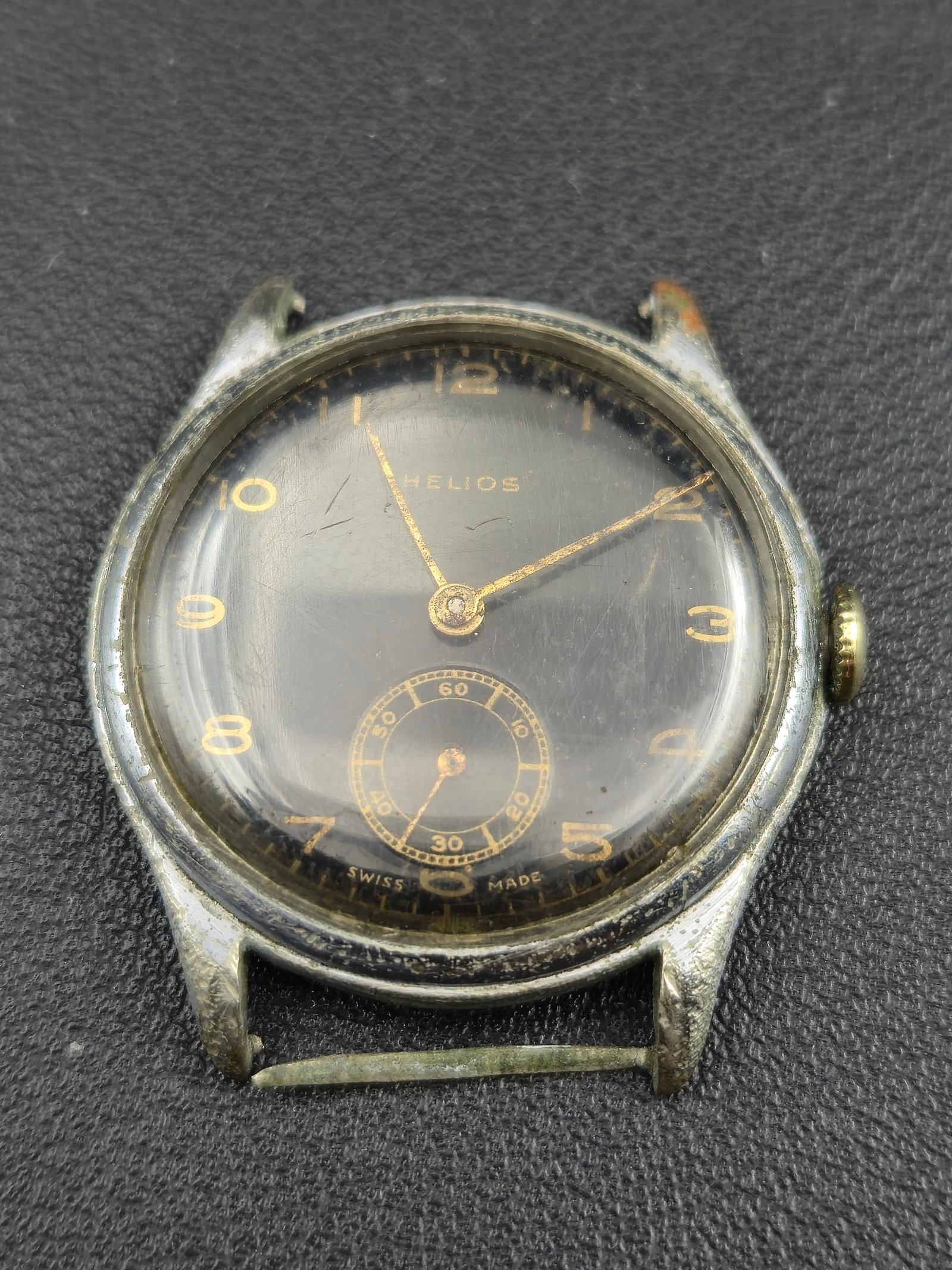 Helios Swiss 15J Black Gilt Dial Manual Wind Wristwatch 34mm (Running): Vintage Helios Swiss wristwatch from the 1940s–1950s, featuring a striking black gilt dial with gold-tone Arabic numerals, a detailed minute track, and a sub-seconds register at 6 o’clock. Powered