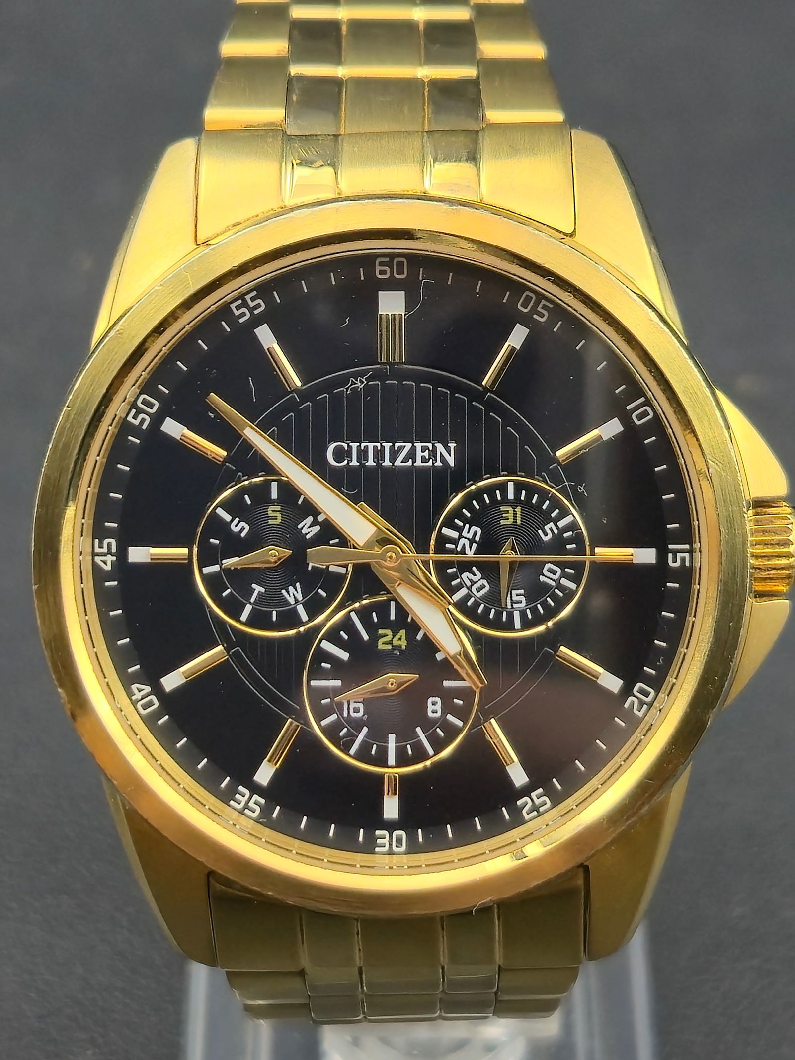 Citizen Quartz 42.5mm Gold-Tone Multifunction Calendar Watch – New Battery – Near Mint: Modern Citizen Quartz wristwatch featuring a sleek black dial with three subdials for day, date, and 24-hour display. The watch is powered by a Japan-made quartz movement (cal. 6329) and has been fitt