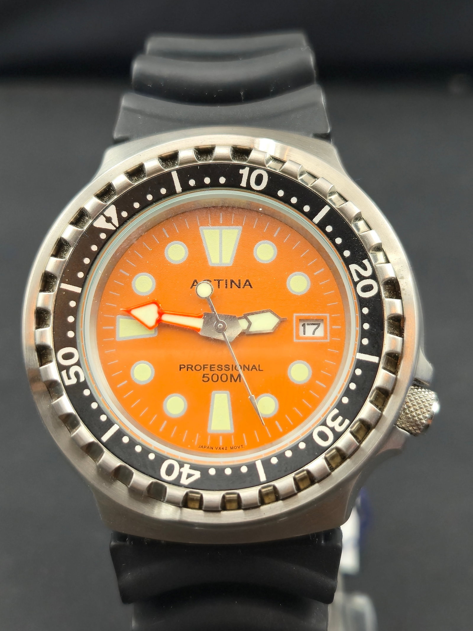 2002 Astina Professional 500M Diver Watch, 46mm Orange Dial – NOS Full Set: A bold and collectible Astina Professional 500M Diver wristwatch, model 7021-145, featuring a vibrant orange dial with luminous indices and hands, framed by a black unidirectional rotating bezel. Powe