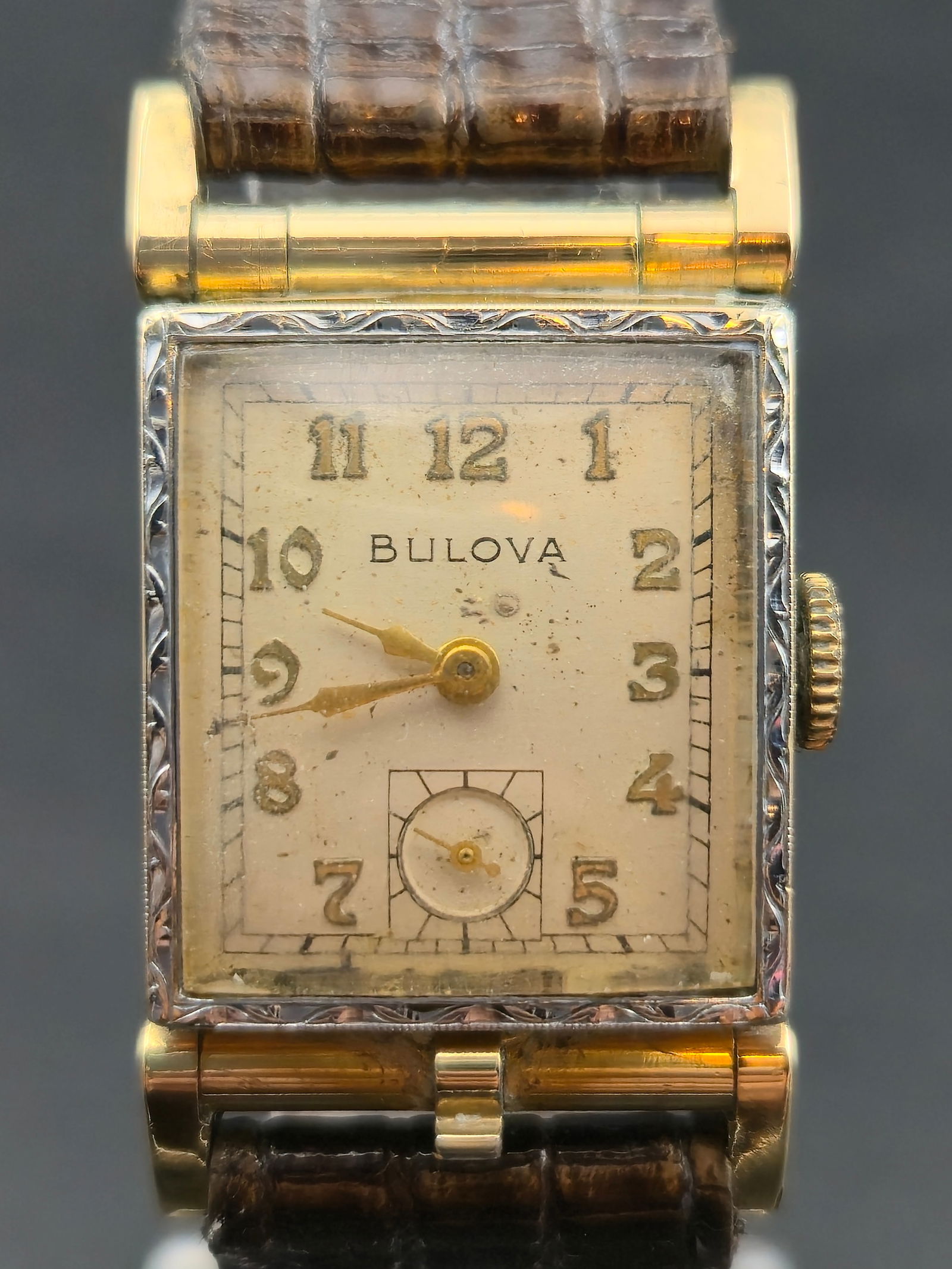 1950 Bulova “Doctor’s Case” 10K Rolled Gold Plate Tank Watch, 21mm – Starts and Stops: handsome 1950 Bulova Doctor’s Case rectangular wristwatch, featuring a hinged-back 10K rolled gold plate case with hand-engraved bezel detailing and stylized lugs. The cream dial displays raised gol