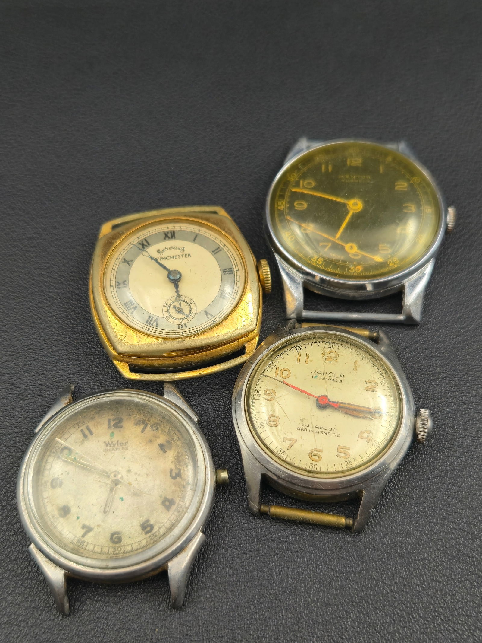 Lot of 4 – Vintage Swiss Watches: Wyler, Horalu, Mentor & Services Winchester: A lot of four mid-century Swiss wristwatches featuring various styles and brands including Wyler, Horalu, Mentor, and Services Winchester. Each displays unique vintage styling such as military-inspire