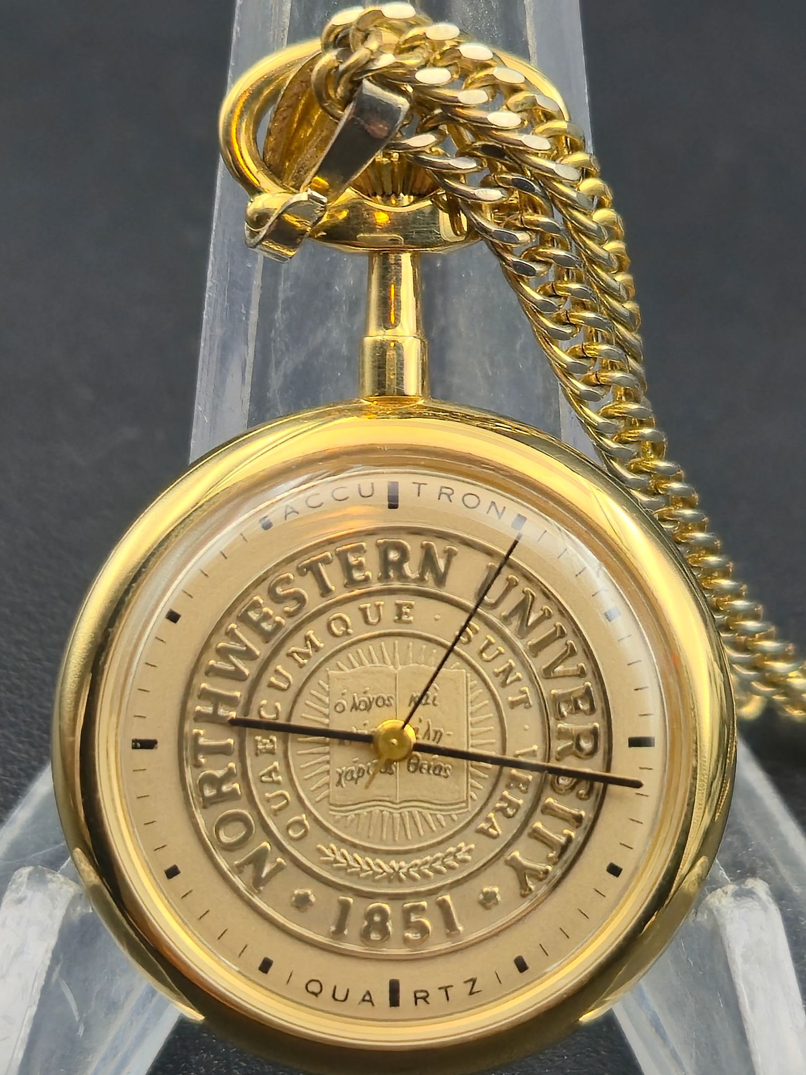 Bulova Accutron Quartz Pocket Watch Northwestern University Seal Gold-Tone 1979 – Runs: Commemorative Bulova Accutron quartz pocket watch, featuring the Northwestern University seal embossed on the dial. The design displays the Latin motto “Quaecumque Sunt Vera” and the founding