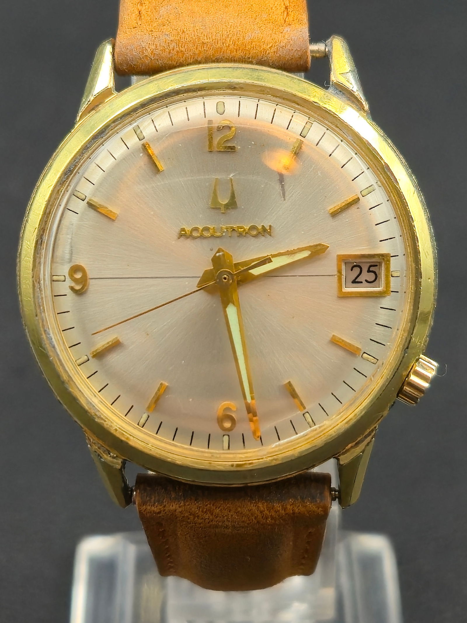 Bulova Accutron 2181 Beloit Corp. 30-Year Presentation Watch (1973, 34mm: Vintage Bulova Accutron wristwatch powered by the Caliber 2181 tuning-fork movement, featuring a gold sunburst dial with gold numerals and markers, dauphine hands, and a framed date window at 3 o’cl