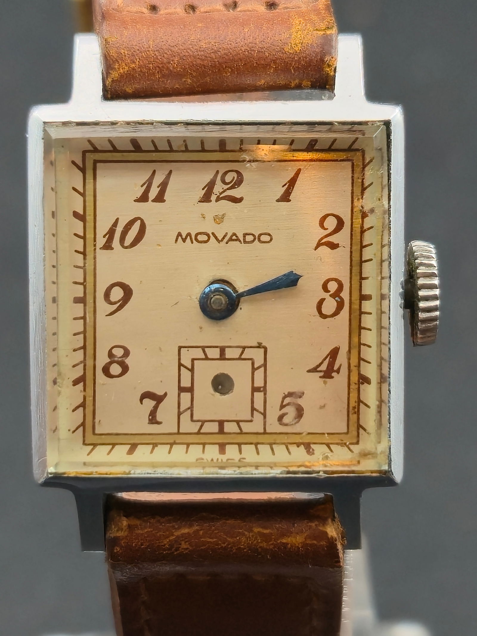 Movado Art Deco 1940s Rectangular Stainless “Jenny” Case Manual 15J Swiss Watch: Elegant vintage Movado rectangular wristwatch from the 1940s Art Deco era, featuring a cream-tone dial with stylized Arabic numerals, blued steel hands, and a recessed sub-seconds register at 6 o’cl