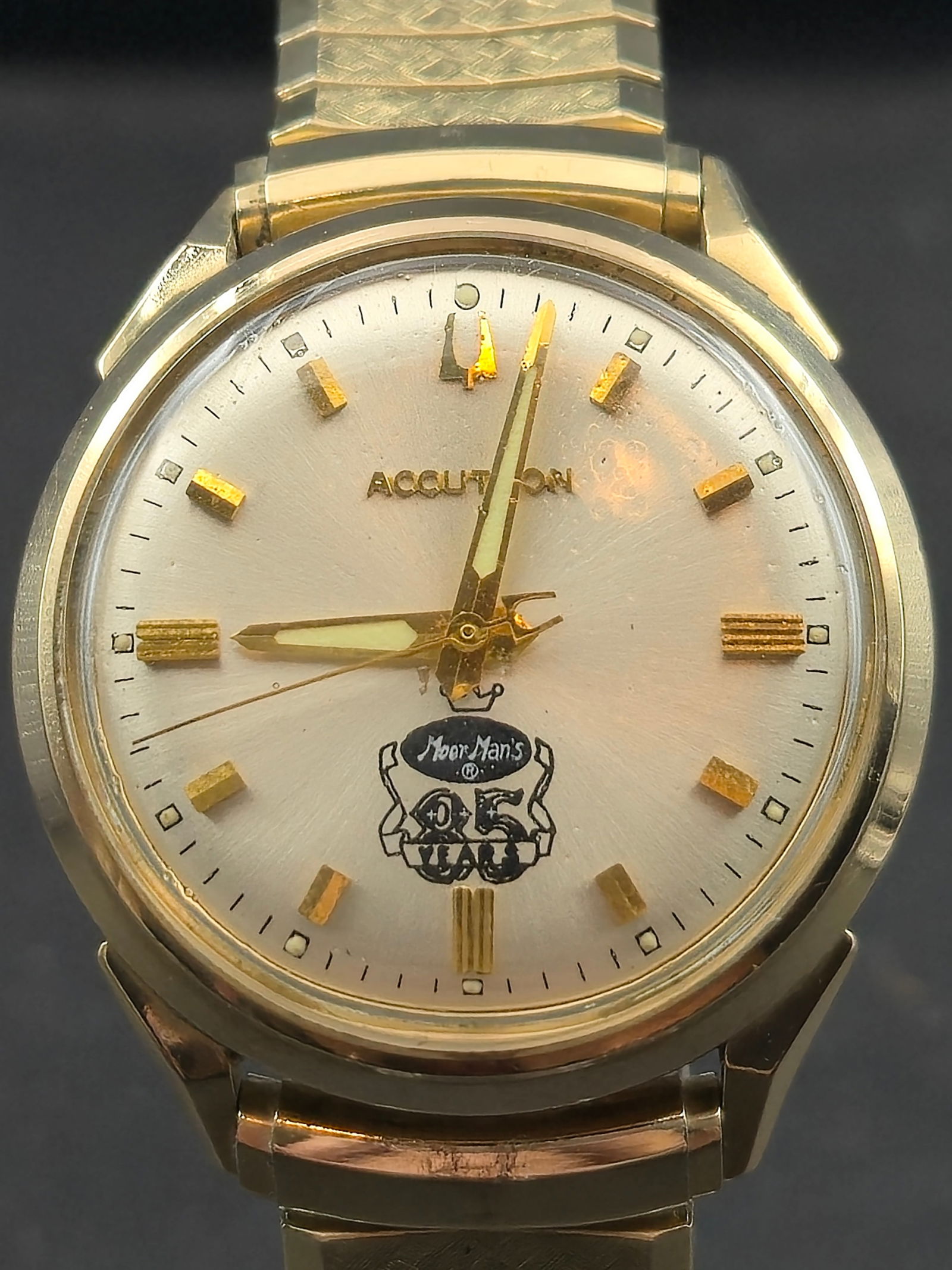 1966 Bulova Accutron 214 “Moorman’s 85 Years” 34mm Gold-Filled Tuning Fork Watch: Vintage Bulova Accutron 214 wristwatch from 1966, created as a corporate presentation piece for Moorman Manufacturing Company to commemorate its 85th anniversary (1881–1966). The silver sunburst dia