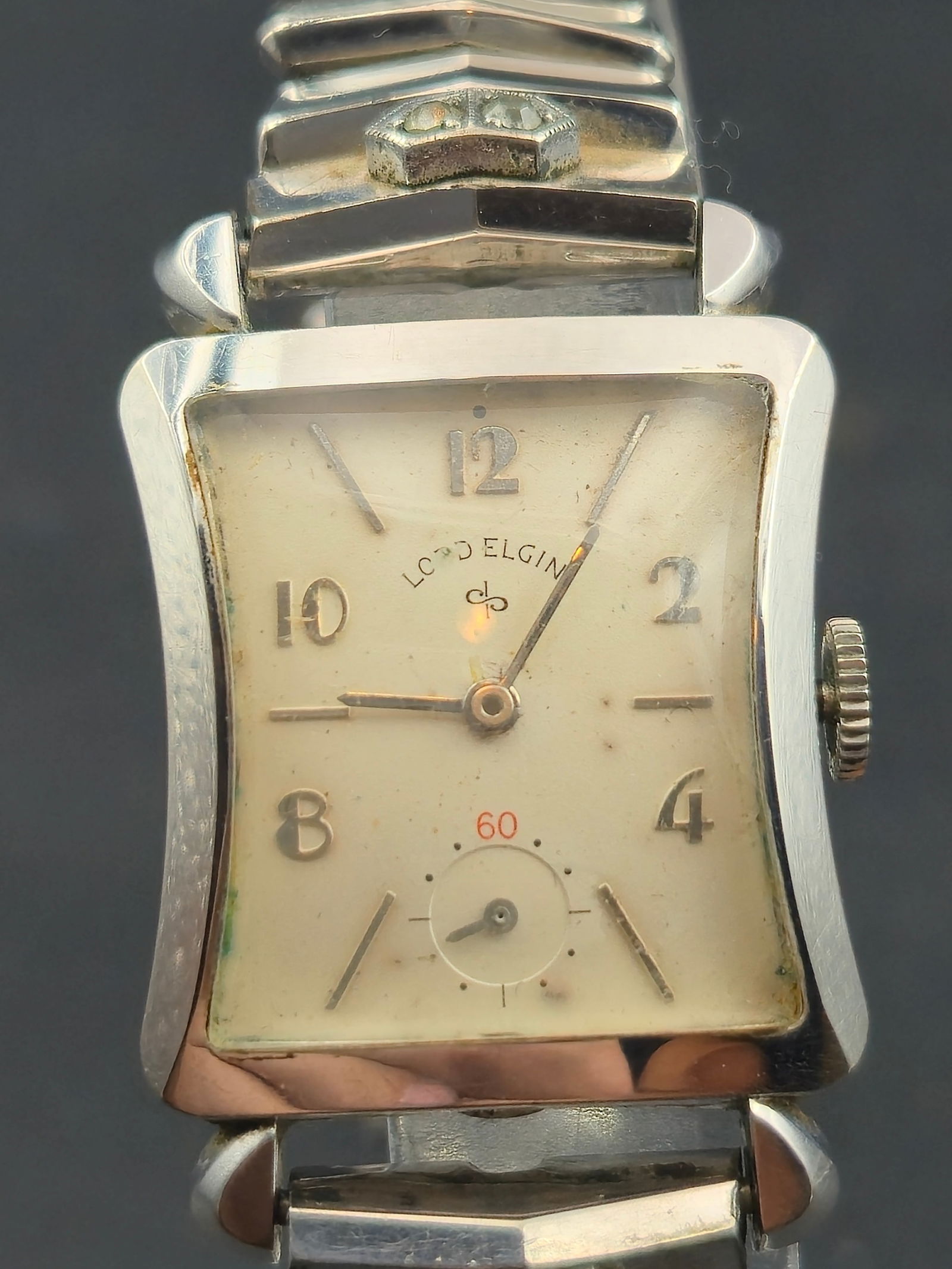 1950s Lord Elgin 14K White Gold-Filled 26mm Tank Wristwatch (Runs: Elegant Lord Elgin men’s wristwatch from the 1950s featuring a curved rectangular 14K white gold-filled Ross case with stepped lugs and classic Art Deco styling. The silver dial bears applied Arabic