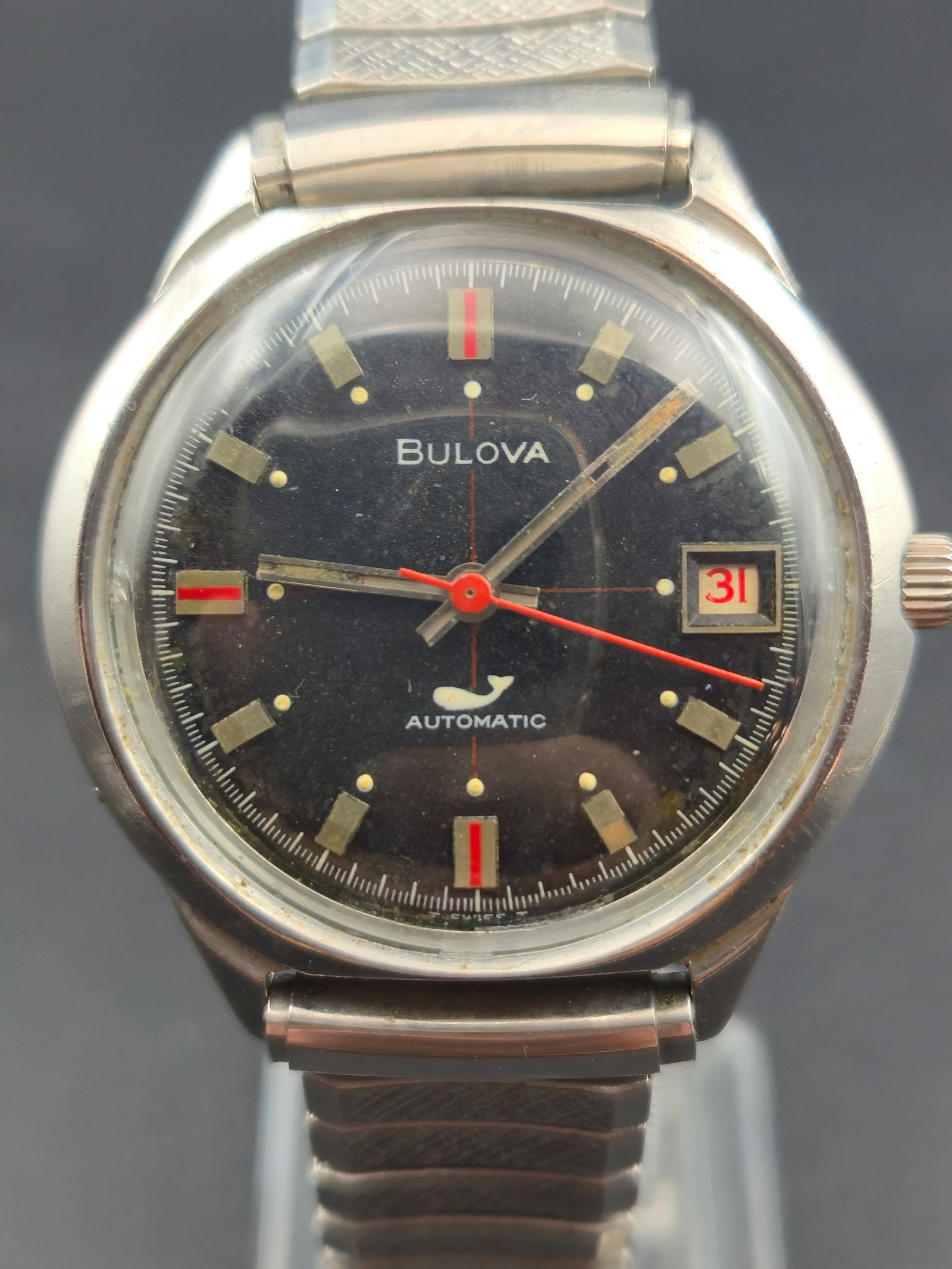 Bulova Automatic “Whale Dial” Stainless Steel Wristwatch (1963, 36 mm, New Crystal, Runs): Vintage 1963 Bulova automatic wristwatch featuring the iconic whale logo dial, symbolizing Bulova’s waterproof design era of the early 1960s. Powered by a Swiss-made 17-jewel automatic movement (Cal