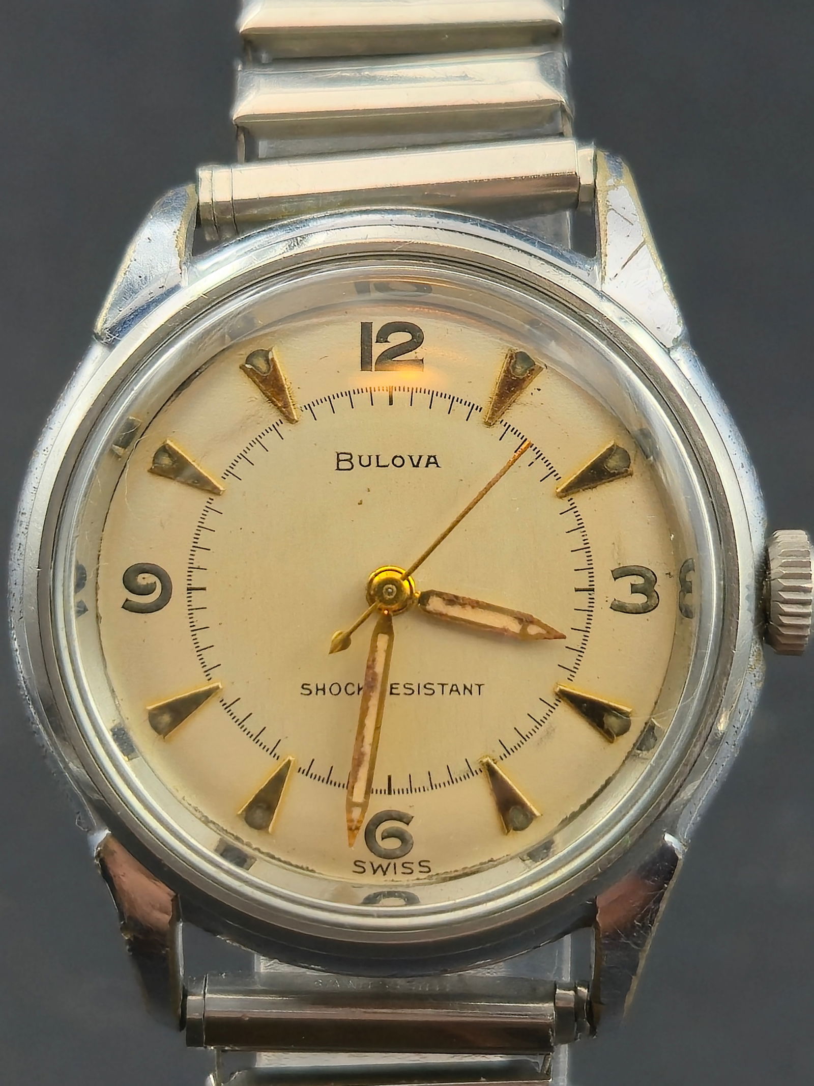 Bulova Shock Resistant Wristwatch 1952 Stainless Steel 33 mm Swiss Runs: Vintage 1952 Bulova Swiss shock resistant wristwatch featuring a silver tone dial with gold Arabic numerals at 12 3 6 and 9 and gold dagger markers between. The watch is powered by a Bulova Caliber 10