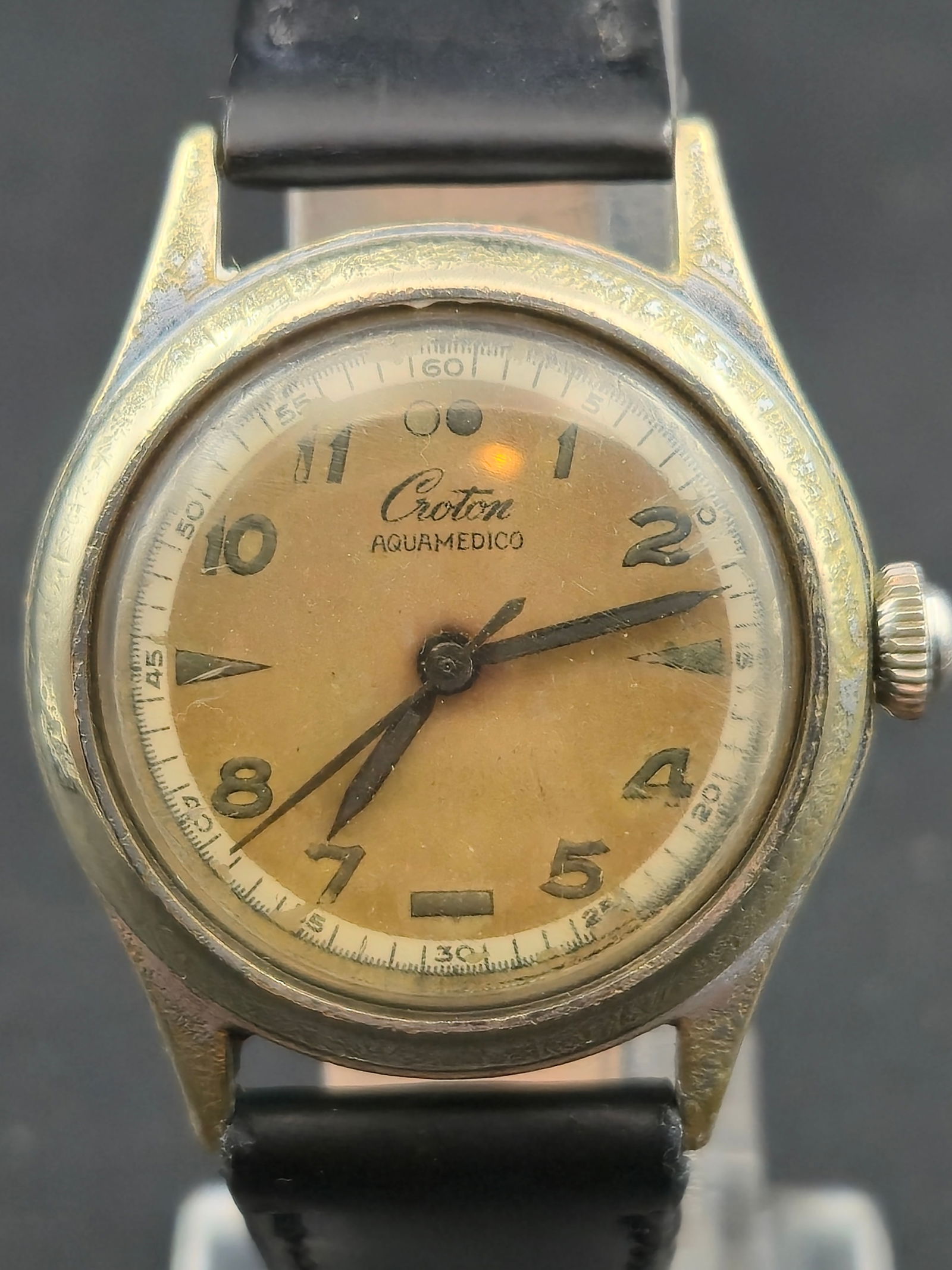 Croton Aquamedico Wristwatch 1950s Swiss 17 Jewel Waterproof 30 mm Runs: Vintage 1950s Croton Aquamedico wristwatch featuring a cream tone dial with luminous Arabic numerals and arrow hands. The watch is powered by a Croton KT1045 manual wind 17 jewel Swiss movement signed