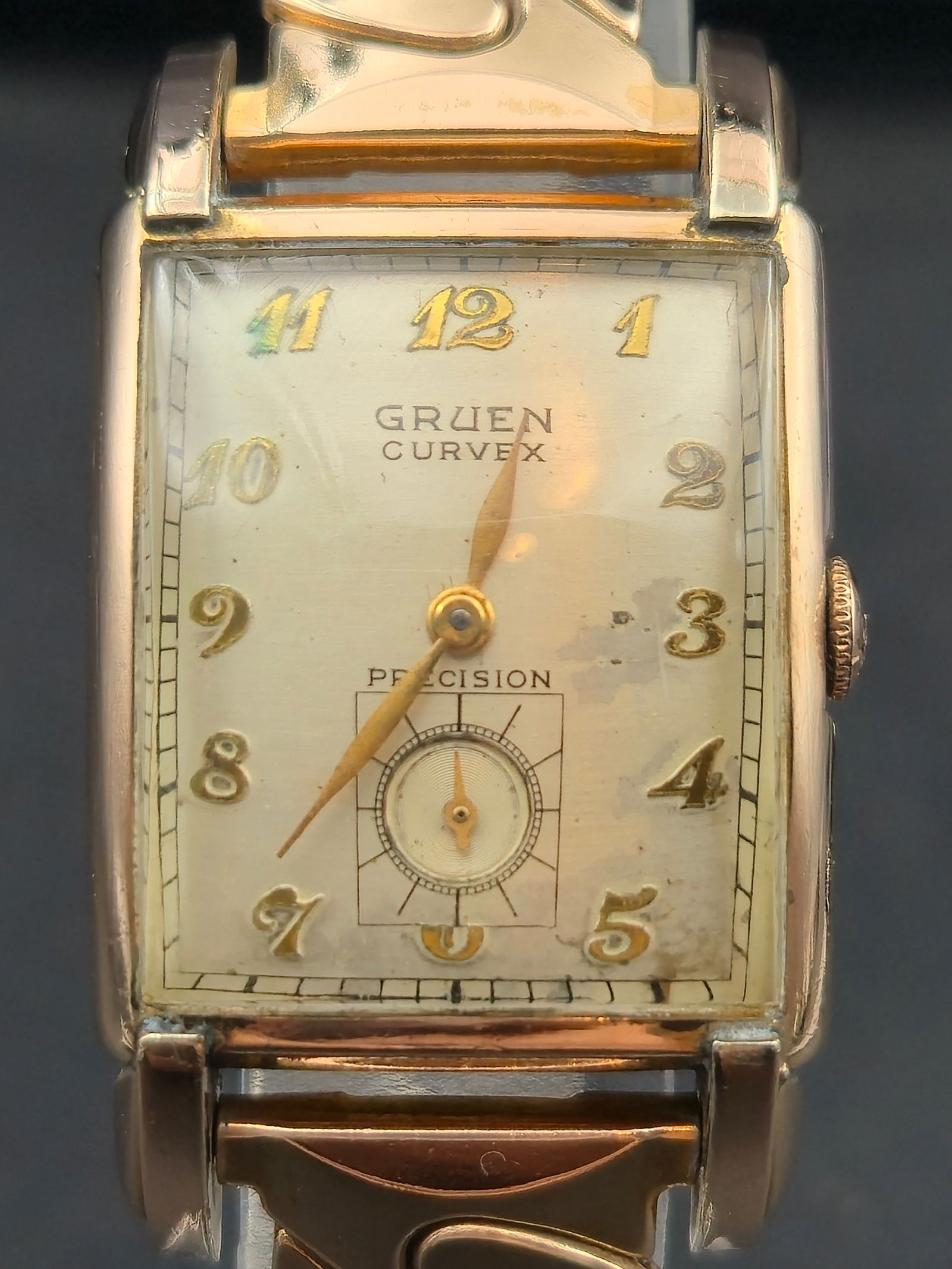 Gruen Curvex Precision Wristwatch 1953 10K Rose Gold Filled 17 Jewel: Vintage 1953 Gruen Curvex Precision wristwatch featuring a curved rectangular 10K rose gold filled case and champagne dial with raised gold Arabic numerals and subsidiary seconds at 6 oclock. Powered
