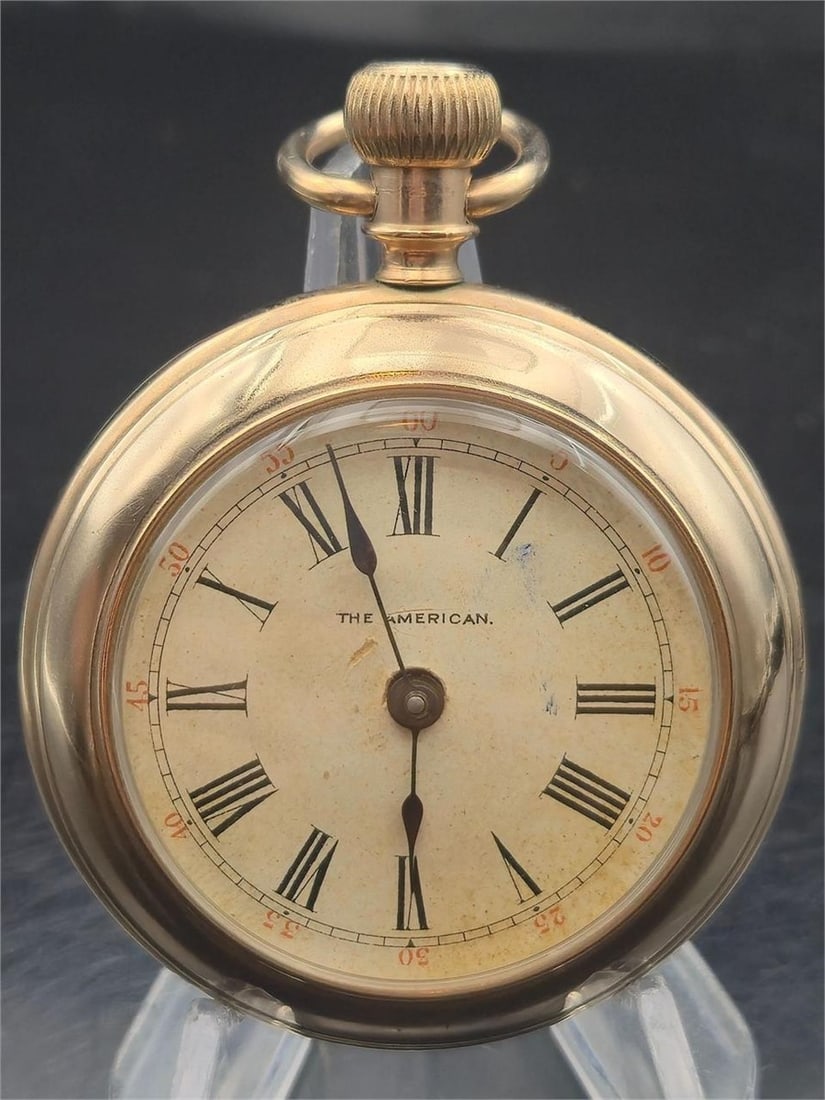 The American Swiss Keyless GoldFilled Pocket Watch: Vintage Swiss-made open-face pocket watch labeled "The American" on the Roman numeral dial. Likely from the early 1900s, this piece features a keyless wind movement with regulator scale marked F / S o