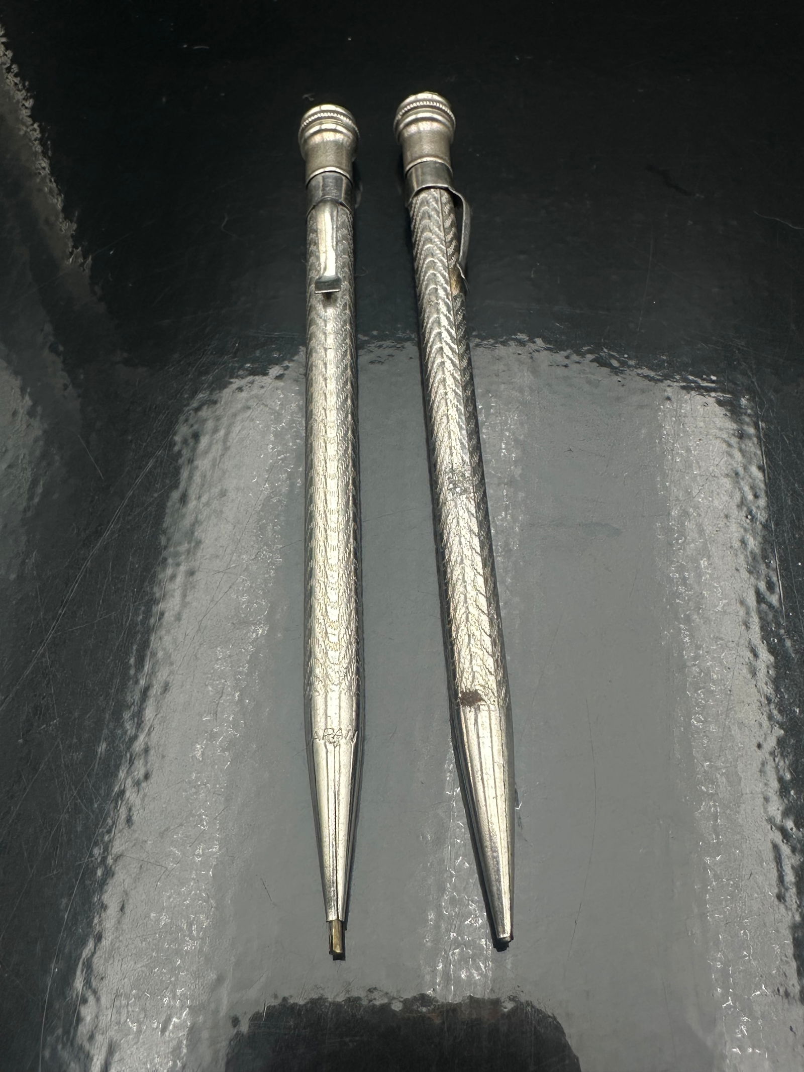 Antique Sterling Silver Engine-Turned Mechanical Pencils, c.1910–1930, Chevron Guilloché Pattern: A fine pair of early 20th-century sterling silver mechanical pencils featuring a hand-engraved engine-turned chevron design. One has a beaded crown top with smooth band, while the other includes a cur