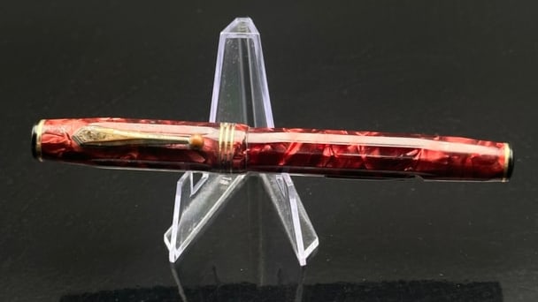 Parker Parkette DeLuxe fountain pen: Vintage Parker Parkette DeLuxe fountain pen in red marbled celluloid, made in the U.S.A. by the Parker Pen Co. The pen features a gold-plated clip and triple cap bands with the original lever-fill mec