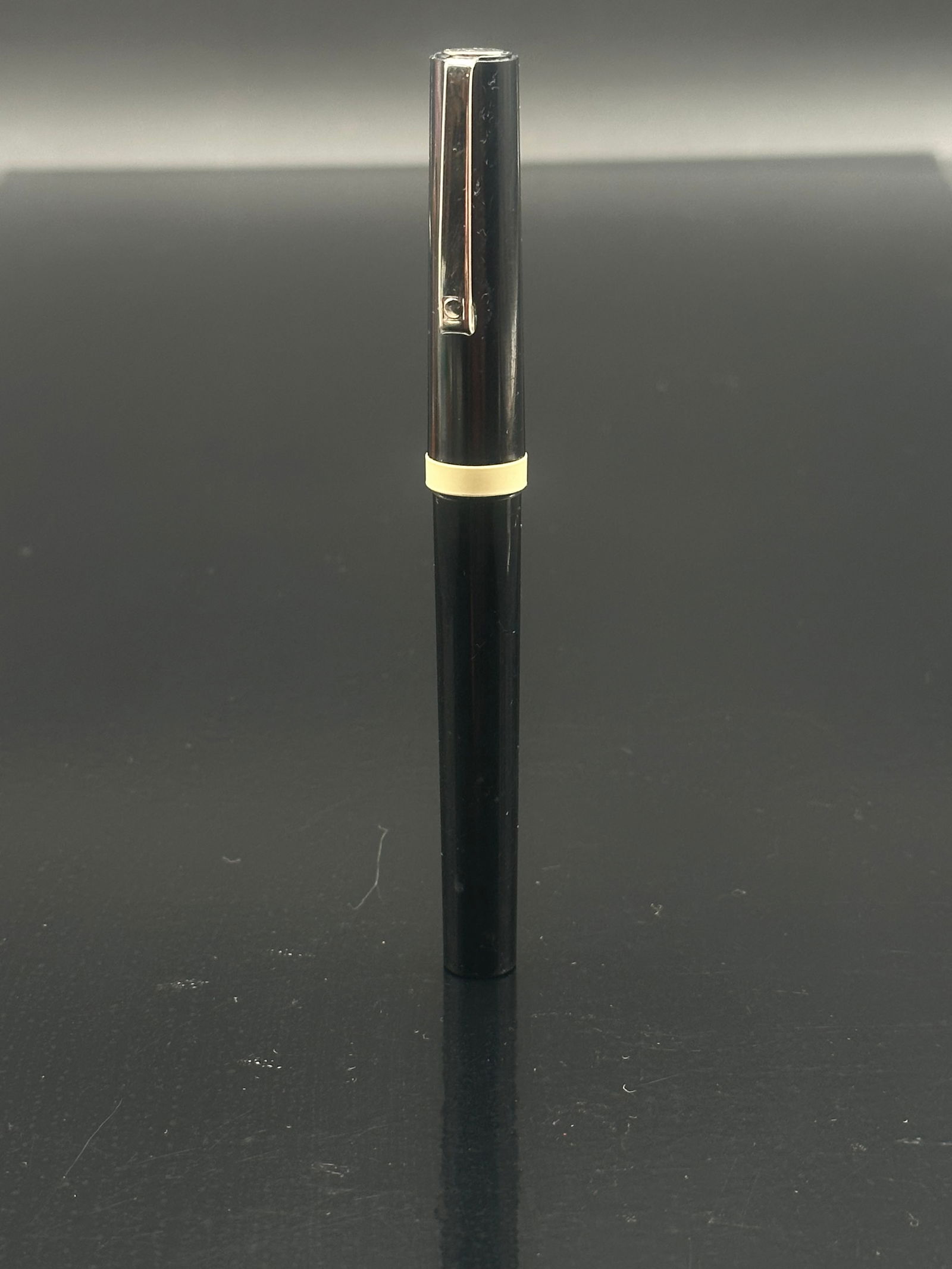 Vintage Osmiroid Calligraphy Fountain Pen – Black with Italic Medium Nib (England): Vintage Osmiroid calligraphy fountain pen, made in England, featuring a black metal body and cap with a gold-tone clip and trim. The pen is fitted with an italic medium gold-plated nib marked “OSMIR