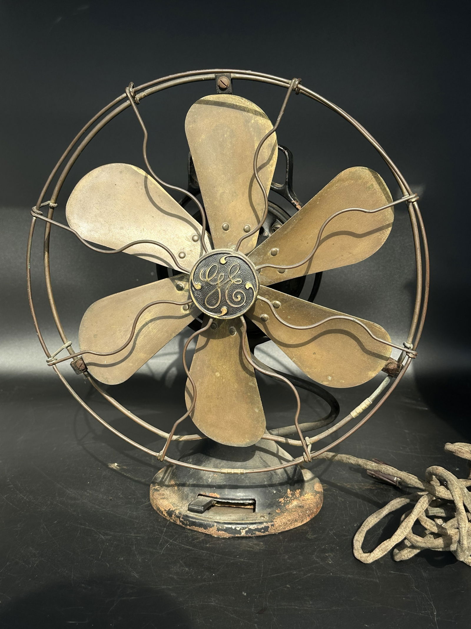 Antique GE Brass Blade 6-Wing 12" Three Star Oscillator Electric Fan: Early General Electric brass-blade electric fan with open-cage guard and cast-iron base. Features six blades with the original “G2" Three Star Oscillating” system, GE medallion center and clot