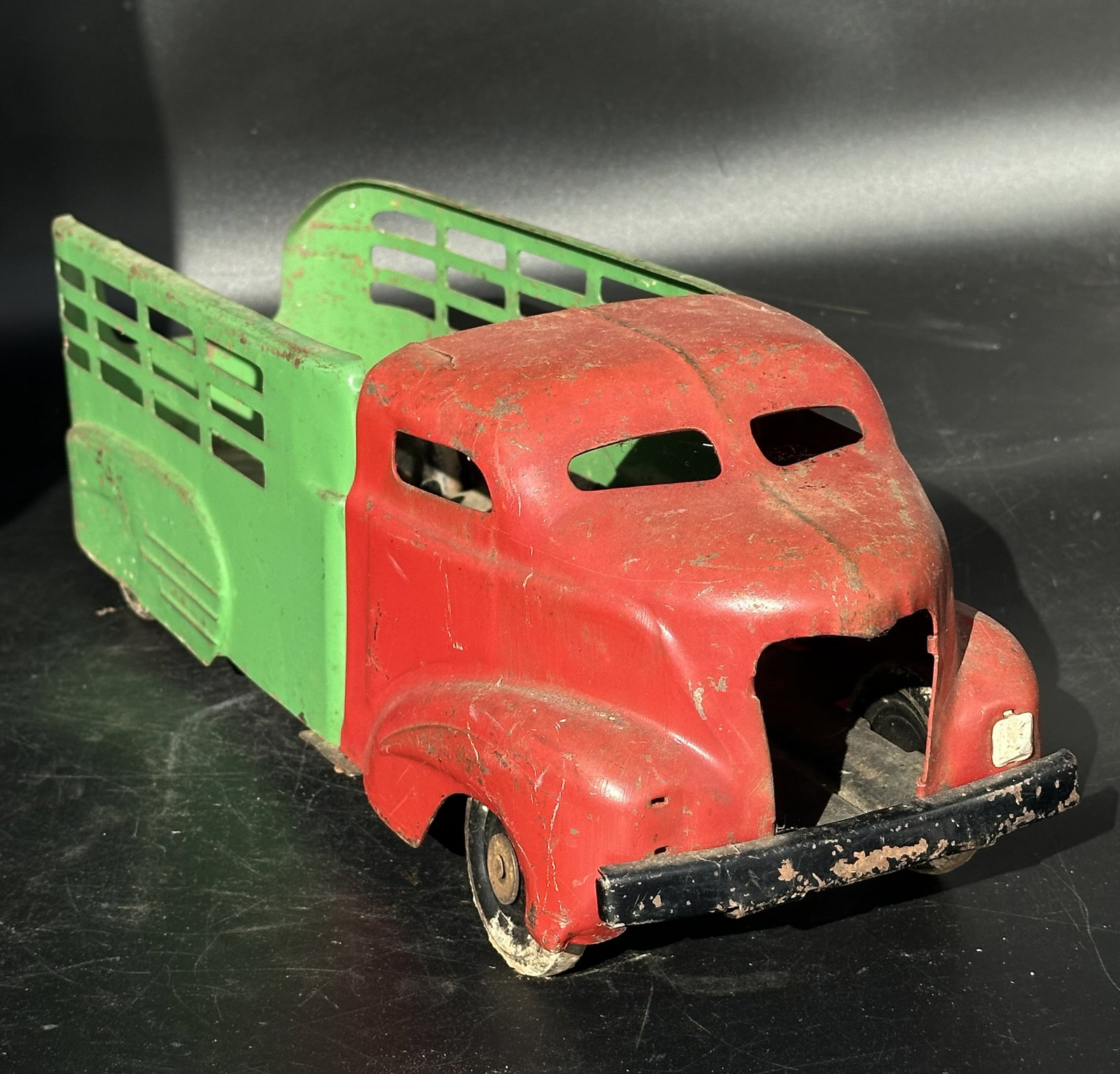 Vintage All-Metal Toy Truck – Pressed Steel Livestock Hauler by All-Metal Products Co.: Classic pressed steel toy livestock truck, made by the All-Metal Products Company (Wyandotte Toys), Wyandotte, Michigan, USA, circa 1930s–1940s. Features a red cab and green stake-bed body with cuto