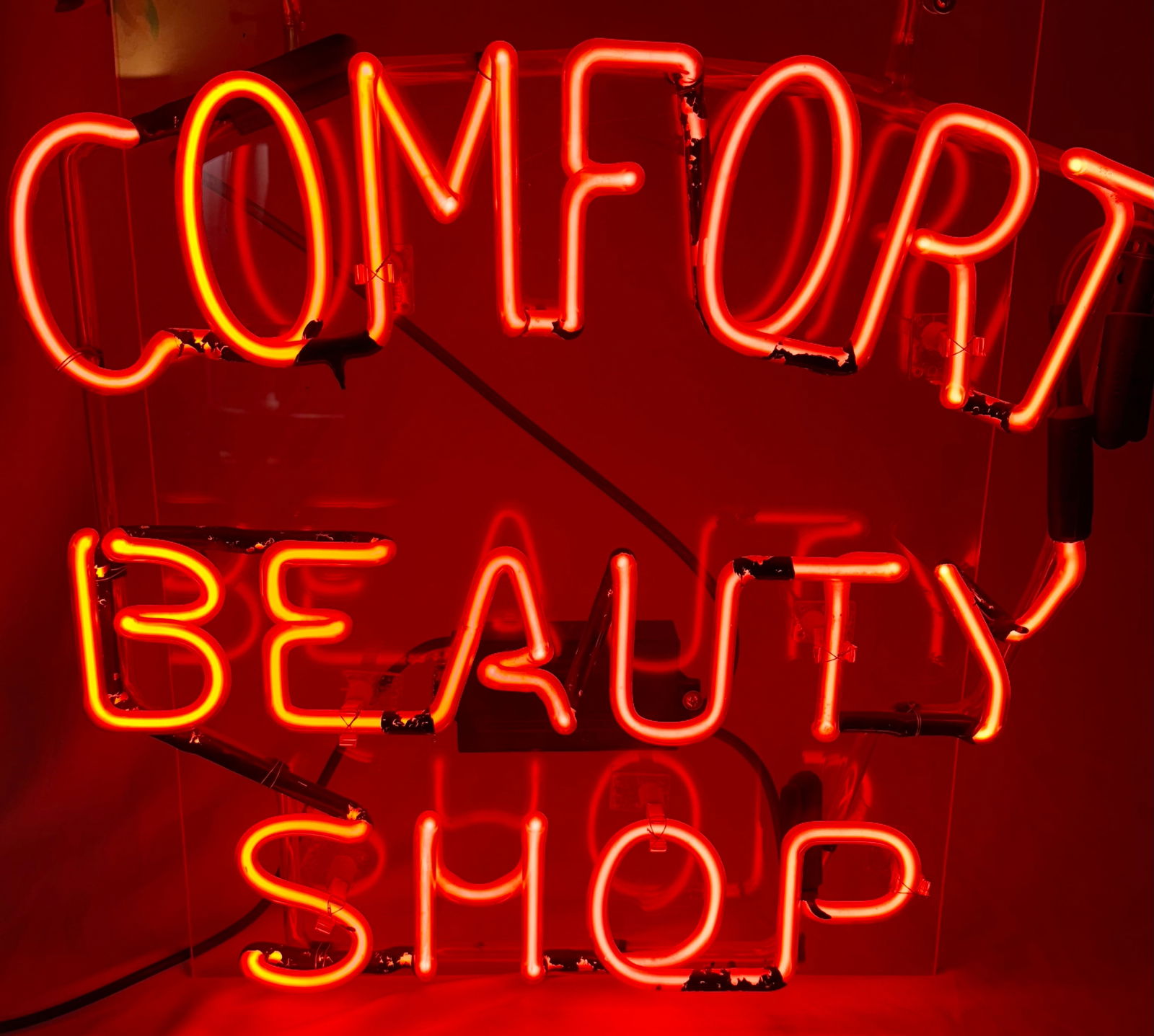 neon sign that reads "COMFORT BEAUTY SHOP".: neon sign that reads "COMFORT BEAUTY SHOP". Neon signs like this are often used to attract customers and enhance the aesthetic of a business, particularly in the beauty and salon industry.