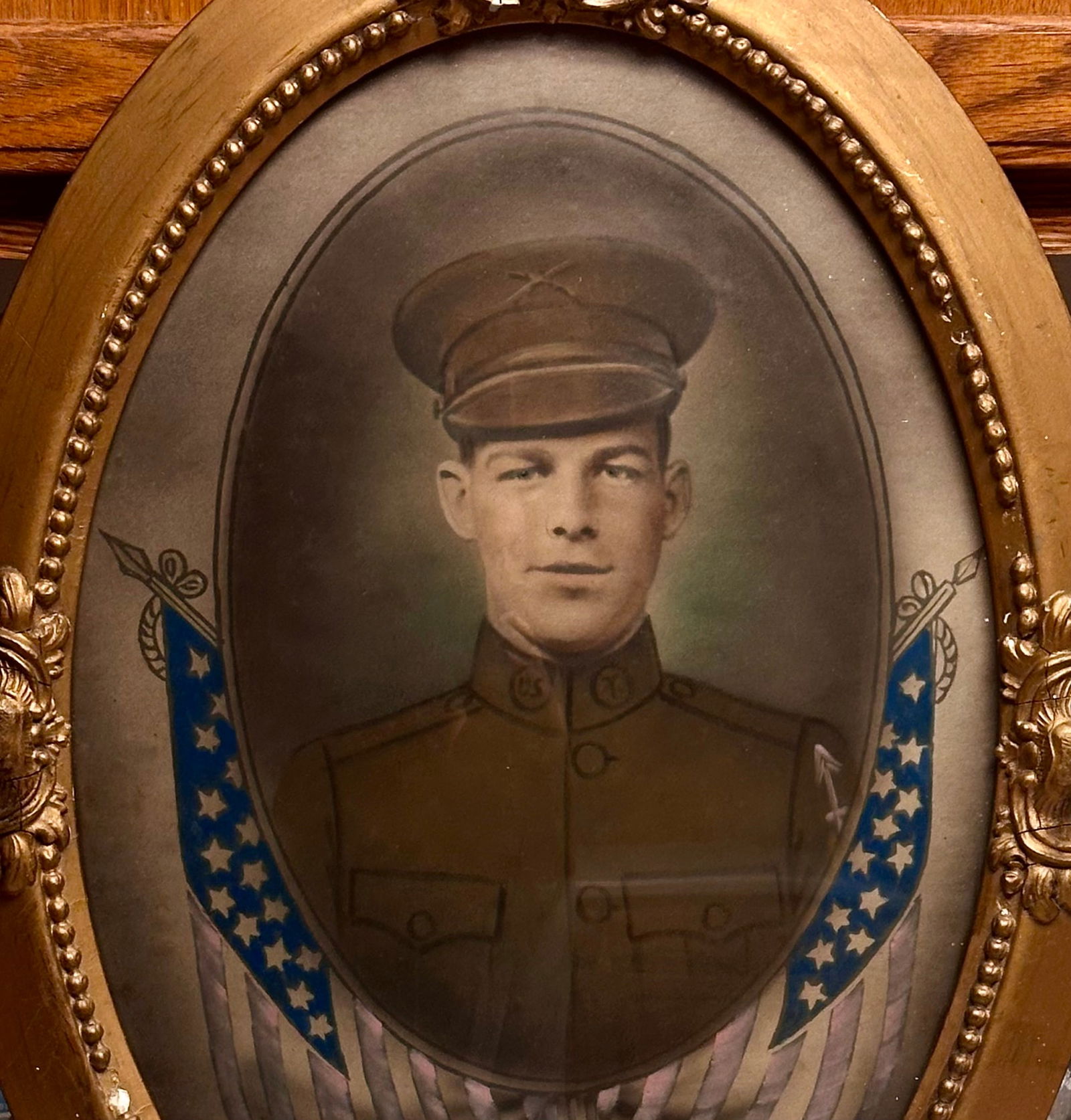 WWI Portrait of Soldier John Francis Howland, 32nd Division, U.S. Army Curved Bubble Glass: Original WWI hand-colored portrait of John Francis Howland, 32nd “Red Arrow” Division, in gilt oval gesso frame with convex glass and patriotic flags. Family history inscribed on back. A fine