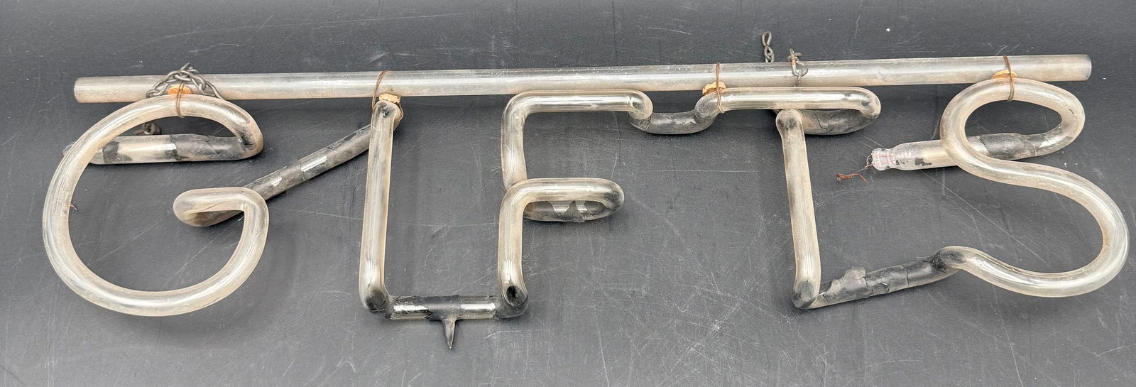 Vintage neon sign that spells out "GIFTS." (1 of 5)